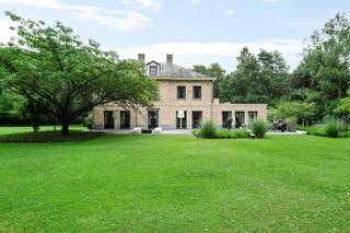 Ontdek deze imposante villa, schitterend gelegen op een riant perceel van 15.088 m², op een uitstekende locatie nabij Golfclub Rinkven en natuur, ideaal voor fiets- en wandelliefhebbers. Deze eigendom combineert een uitzonderlijke woonkwaliteit met de mogelijkheid tot werken aan huis, omringd door rust, groen en privacy.<br /><br /><strong>Indeling</strong><br />Bij binnenkomst betreedt u een indrukwekkende inkomhal met gastentoilet en vestiaire. Van hieruit heeft u toegang tot twee afzonderlijke bureauruimtes, ideaal voor professioneel gebruik of thuiswerk, en tot de royale leefruimte.<br /><br />De ruime woonkamer met zithoek en eetkamer baadt in het licht dankzij de grote raampartijen en sluit naadloos aan op de ruime leefkeuken. Deze is volledig uitgerust met hoogwaardige toestellen, een gezellige open haard, en biedt een panoramisch uitzicht op de prachtig aangelegde tuin. Aansluitend vindt u een praktische bijkeuken, die directe toegang geeft tot de inpandige garage en het binnenzwembad.<br /><br />Uniek aan deze woning is het volledig geïntegreerde zwembad en infrarood sauna. Hier geniet u het hele jaar door van pure ontspanning. Dankzij de grote ramen heeft u een prachtig zicht op de tuin en directe toegang tot een terras.<br /><br />De ruime, inpandige garage biedt plaats aan twee wagens. In de kelder bevinden zich de technische installaties, bergruimte en de zwembadinstallatie.<br /><br />Op de eerste verdieping bevindt zich een royale nachthal met vide, die toegang geeft tot de indrukwekkende mastersuite. Deze omvat een ruime slaapkamer, een aparte dressing en een luxueuze badkamer met ligbad, inloopdouche, dubbele wastafel en toilet. Verder vindt u hier nog twee grote slaapkamers, die een tweede badkamer delen.<br /><br />De volledig afgewerkte tweede verdieping doet momenteel dienst als zelfstandig appartement met woonruimte, slaapkamer en eigen badkamer, ideaal als gastenverblijf of au pair.<br />De zorgvuldig aangelegde parktuin biedt volledige privacy en rust. Meerdere zonneterrassen geven u de mogelijkheid om op elk moment van de dag van de buitenlucht te genieten, in alle discretie.<br /><br /><strong>Bijzonderheden</strong><br />+ Uitgebreide renovatie en uitbreiding in 2010<br />+ Totale perceeloppervlakte: 15.088 m²<br />+ Grote bewoonbare oppervlakte, ideaal voor grote gezinnen of woon/werkcombinatie<br />+ Vloerverwarming, CV op gas, alarmsysteem, videofoon, waterontharder, tuinverlichting, beregeningssysteem, regenwaterput, automatische toegangspoort.<br />+verwarmd binnenzwembad met sauna <br />+Elektra conform, asbestvrij, EPC= B