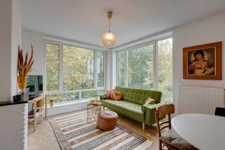 <p><strong>Wonen in een gebouw ontworpen door Renaat Braem, met het Te Boelaerpark als decor? Dat is niet bepaald dagelijkse kost - maar toch stellen we je er vandaag trots aan voor. In de gegeerde buurt rond de Gitschotellei in Borgerhout vind je dit bijzonder charmante appartement op een derde verdieping, met open zicht op het groen en een overvloed aan natuurlijk daglicht. Het gebouw maakt deel uit van de Nationale Werf, een naoorlogs woonproject waaraan Braem samen met Geo Brosens en Florent Laforce zijn architecturale stempel drukte. Een droomplek voor architectuurliefhebbers, maar evengoed voor wie graag compact en slim woont op een locatie waar je alles binnen handbereik hebt. Kom binnen…</strong></p><p><strong>Een inkom die meer kan dan verwelkomen</strong></p><p>De hal is hier meteen meer dan een doorgang. Een van de ingemaakte kasten verbergt namelijk een ingebouwd bureautje. Een slimme oplossing die optimaal gebruikmaakt van de beschikbare ruimte, zonder dat je er een aparte kamer voor nodig hebt. Ideaal voor wie af en toe thuiswerkt of gewoon graag een eigen plekje heeft om rustig iets af te handelen.</p><p><strong>De woonkamer met het park als decor</strong></p><p>Dankzij de hoekligging op de derde verdieping valt het daglicht hier rijkelijk naar binnen. En dan is er natuurlijk dat open zicht op het Te Boelaerpark. De woonkamer voelt ruim aan en krijgt extra karakter door de knappe vloer en het gebruik van ruwe, natuurlijke materialen. Een plek waar je met plezier neerploft, terwijl het groen buiten voor een bijzonder aangenaam uitzicht zorgt.</p><p><strong>Een open keuken waar alles samenkomt</strong></p><p>De open keuken sluit mooi aan op de leefruimte en de eethoek. Ze is volledig uitgerust met een oven, kookplaat, ingebouwde afzuigkap, koelkast, diepvries en afwasmachine. Alles wat je nodig hebt om uitgebreid te koken of snel iets op tafel te zetten, is dus binnen handbereik. En doordat keuken, eethoek en woonkamer samen één geheel vormen, blijf je ook tijdens het koken beschikbaar voor je gezelschap.</p><p><strong>Een badkamer met een zachte toets</strong></p><p>De moderne badkamer combineert een ruime inloopdouche met een leuk beige tegeltje en aansluiting voor een wasmachine. Een fijne plek voor wie 's ochtends graag vlot op gang komt, maar 's avonds evengoed de tijd wil nemen om even te ontspannen.</p><p><strong>Twee slaapkamers, allebei hun eigen plek</strong></p><p>Het appartement heeft twee slaapkamers met een praktische indeling. Of je nu een extra kamer zoekt voor een kind, gasten of een andere invulling: je krijgt hier de flexibiliteit om de ruimtes aan je eigen leven aan te passen.</p><p><strong>Handig om weten</strong></p><p>Er is een apart toilet, handig voor het dagelijkse comfort. Daarnaast kun je gebruikmaken van een afgesloten keldertje, altijd fijn om spullen op te bergen die je niet elke dag nodig hebt.</p><p>Verliefd? Antwerpen@ugly.be</p>
