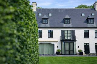 Op absolute toplocatie gelegen prachtige Herenwoning met ca. 5566 vierkante meter, met o.a. een discreet geïntegreerde service-unit met eigen toegang en interne ontsluiting, verwarm zwembad en volwassen tuin.<br /><br />Indeling gelijkvloers; ruime entree centrale aslijn, vestiaire en gastentoilet, ruim salon met eiken planken en knappe gashaard, aanpalend tuinkamer met bar en zitruimte, aparte gezellige tv kamer voorzien van ingemaakte kasten en home theater, riante leef-keuken met Aga-fornuis, eetkamer en zitgedeelte, toegang naar ontspanningsruimte met hamam, kleedruimte en toilet wat mooi aansluit bij het zwembad met ingebouwde whirlpool in de tuin, toegang naar unieke wijnkelder voorzien van koeling, voorraadkelder, technische ruimte en zwembadkelder. Garage voor drie wagens met automatische poorten en handige fietsenberging met extra brede deur. Tweede entree met trap naar de service-unit (conciërge) welke voorzien van een ruime living met open keuken, slaapkamer met kasten en badkamer.<br /><br />Indeling verdieping;<br />Overloop waarop uitkomen, een supermooi oudersuite met slaapgedeelte, dressing voor haar en dressing voor hem en een luxe badkamer, tweede ruime slaapkamer met dressing, duplex en eigen badkamer, derde ruime slaapkamer met dressing en eigen badkamer, en een ontsluiting naar de service-unit (conciërge).<br />Indeling tweede verdieping; een vierde en vijfde ruime slaapkamer en badkamer, berging, en apart toilet.<br />Opmerkingen: bouwjaar 1996, upgrade 2014.