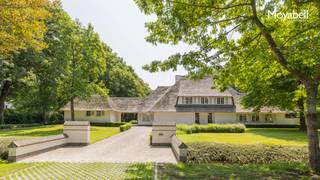 In het hart van het prestigieuze Scheutbos – een van de meest gegeerde locaties van Vlaanderen – bevindt zich deze unieke, rietgedekte villa uit 2000. Met een woonoppervlakte van maar liefst 500 m² op een riant hoekperceel van 5.529 m², biedt deze eigendom een uitzonderlijke combinatie van rust, ruimte en klasse. Deze villa in landelijke stijl ademt authenticiteit, terwijl ze moeiteloos voldoet aan de hoogste hedendaagse comfortnormen. De royale inkomhal verwelkomt u met een warme elegantie en beschikt over een vestiaire en gastentoilet. De ruime living met imposante glaspartijen baadt in natuurlijk licht en biedt een panoramisch zicht op de groene tuin. De open keuken met kookeiland vormt het kloppend hart van het huis, naadloos verbonden met een ruime eetplaats – perfect voor stijlvolle diners en gezellige familiemomenten. De woning beschikt over vijf volwaardige slaapkamers en twee smaakvol afgewerkte badkamers, waardoor zowel privacy als comfort verzekerd zijn. Een praktische wasplaats verhoogt het dagelijkse gemak, terwijl de inpandige garage ruimte biedt aan twee wagens – met bovendien extra parkeergelegenheid op het perceel zelf. Het bijgebouw biedt tal van mogelijkheden: van praktijkruimte voor vrije beroepen tot een atelier, gastenverblijf of hobbyruimte. Wilt u wonen in een oase van rust met vlotte verbindingen en alle luxe binnen handbereik? Dan is dit unieke pand in Scheutbos uw ultieme droomwoning. De woning wordt gedeeltelijk gemeubeld verhuurd. EPC 257 kWh/m2
