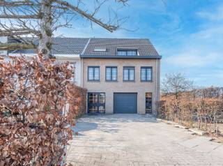 <p>Ontdek deze bijzonder ruime en perfect onderhouden woning met tal van mogelijkheden, ideaal voor zowel een gezin als een vrij beroep of thuiswerk!</p>
<p>Bij het betreden van de woning komt u in een royale inkomhal met geïntegreerde bureauruimte en vestiaire — perfect voor wie wonen en werken wil combineren. Van hieruit heeft u toegang tot de ruime garage met automatische rolpoort. Achteraan bevindt zich een praktische en grote wasruimte, een fraaie badkamer en een polyvalente kamer die zich leent tot diverse invullingen (praktijkruimte, hobbykamer, extra slaapkamer…). Deze verdieping biedt bovendien directe toegang tot de mooi aangelegde tuin en het terras.</p>
<p>Op de eerste verdieping geniet u van een lichtrijke en ruime leefruimte met geïntegreerde keuken en een gezellige haardpartij. Deze vloeit naadloos over in de veranda, uitgerust met zonnescreen, en het aansluitende overdekte terras. Het terras beschikt over een stijlvol lamellendak dat u naar wens open of dicht kan zetten — ideaal om het hele jaar door te genieten. Verder vindt u op deze verdieping een apart toilet en een luxueuze, ruime badkamer met massagedouche, dubbele wastafel en een royaal ligbad.</p>
<p>De slaapverdieping omvat twee volwaardige ruime slaapkamers en een kinderkamer, allen bereikbaar via de nachthal. Daarnaast is er een praktische garderobekast en een ruim toilet met bidet, met de mogelijkheid om dit om te vormen tot een extra douchekamer.</p>
<p>Deze instapklare woning combineert ruimte, comfort en flexibiliteit op een uitstekende locatie met vlotte bereikbaarheid en voldoende parkeergelegenheid. Een unieke kans voor wie op zoek is naar een veelzijdig eigendom met karakter!</p>