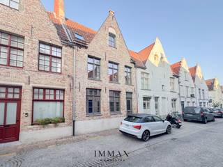 Volledig gerenoveerde stadswoning met zonnige binnenkoer in hartje Brugge!<br /><br />In het sfeervolle Sint-Gilliskwartier, een rustige en charmante wijk in het hart van Brugge, wacht achter een authentieke gevel een verrassend ruime en volledig gerenoveerde woning op haar nieuwe eigenaar. Deze karaktervolle woning onderging in 2019 een totaalrenovatie met oog voor detail, comfort en duurzame, kwalitatieve materialen.<br /><br />Bij het betreden van de woning kom je terecht in een uitnodigende inkomhal met praktische bergruimte en een gastentoilet. De lichtrijke leefruimte straalt warmte en gezelligheid uit, met een voorziening voor een gashaard die het geheel nog sfeervoller kan maken. Aansluitend bevindt zich de open leefkeuken die volledig werd uitgerust met hoogwaardige toestellen: een inductiekookplaat, oven, microgolf, vaatwasmachine, frigo, diepvries én een luxe Aqualex-kraan (koud water - spuitwater - kamertemperatuur) <br /><br />Achter de keuken ligt een handige berging met aansluitingen voor een wasmachine en extra technische voorzieningen.<br /><br />Op de eerste verdieping bevindt zich een ruime slaapkamer met inbouwkasten, evenals een stijlvolle badkamer die werd afgewerkt in Mortex en voorzien is van een inloopdouche, toilet en lavabo. De tweede verdieping biedt een tweede ruime slaapkamer aan, ook hier met ingemaakte kasten.<br /><br />Als kers op de taart beschikt deze woning over een zonnige en ruime binnenkoer: een buitenruimte waar het heerlijk vertoeven is in alle rust, midden in de stad. Een extra troef is de zeer beperkte inkijk, waardoor privacy gewaardborgd blijft. <br /><br />Deze instapklare woning combineert modern wooncomfort met authentieke charme en is de perfecte keuze voor wie wil genieten van rustige luxe in een bruisende stadsomgeving — of voor wie op zoek is naar een waardevaste investering in het hart van Brugge.<br /><br />Voor meer informatie of een vrijblijvend bezoek, contacteer Jana via jana@immax.be of via 0498 10 98 98