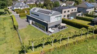 Deze uitzonderlijke designvilla, ontworpen door het gerenommeerde architectenbureau Drieskens & Dubois, vormt een bijzonder geslaagde symbiose tussen tijdloze architectuur, hedendaags wooncomfort en de omliggende natuur.<br /><br />Royale raampartijen laten het daglicht overvloedig binnenstromen en creëren vanuit vrijwel elke leefruimte een prachtig panoramisch uitzicht op het omliggende groen. De woning is integraal uitgerust met screens en beschikt in de leefruimte bovendien over nieuwe, aanvullende jaloezieën. Zo geniet u op elk moment van een optimale lichtbeleving én maximale privacy.<br /><br />De villa bevindt zich op een bijzonder rustige locatie, vlak bij het Herkenrodebos, midden in een oase van groen. Ondanks deze serene ligging zijn centra, winkels en belangrijke verbindingswegen vlot bereikbaar. Een zeldzame combinatie van rust, privacy en bereikbaarheid.<br /><br />Architectuur die ruimte en licht centraal stelt<br /><br />Van bij het binnenkomen wordt u getroffen door het uitzonderlijke gevoel van ruimte. De royale plafondhoogtes, open architectuur en overvloedige natuurlijke lichtinval zorgen voor een indrukwekkende loftbeleving.<br /><br />Binnen- en buitenruimte vloeien haast naadloos in elkaar over, terwijl de zorgvuldig gekozen materialen, warme kleuren en hoogwaardige afwerking voor een bijzonder aangename en stijlvolle woonsfeer zorgen.<br /><br />Het hart van de villa wordt gevormd door de royale leefruimte met:<br /><br />een stijlvolle zithoek met sfeervolle gashaard;<br />een elegante en lichtrijke eetruimte;<br />een tijdloze open designkeuken met twee kookeilanden, hoogwaardige toestellen en bijzonder veel maatwerk.<br /><br />De keuken is onder meer uitgerust met een combi-luchtoven, vaatwasser, koelkast en gaskookplaat. De talrijke op maat vervaardigde kasten zorgen voor een zee aan praktische en discreet geïntegreerde bergruimte.<br /><br />Zon, groen en absolute privacy<br /><br />Via de grote schuiframen bereikt u rechtstreeks het zuidwestelijk georiënteerde terras, waar u optimaal van de middag- en avondzon geniet.<br /><br />De volledig omheinde tuin is een absolute troef voor wie privacy hoog in het vaandel draagt. De natuurlijke omgeving rond de villa versterkt het gevoel van rust en exclusiviteit. Een belangrijk bijkomend voordeel is dat het natuurlijke terrein rondom de woning niet bebouwd mag worden, waardoor het open en groene karakter van de omgeving duurzaam gevrijwaard blijft.<br /><br />Op het gelijkvloers bevinden zich verder:<br /><br />een ruim gastentoilet;<br />een royale vestiaire;<br />een dubbele inpandige garage, waarvan de garagepoort voorzien is van een vernieuwde motorinstallatie.<br />Multifunctionele ondergrondse verdieping<br /><br />De volledig onderkelderde verdieping biedt een aanzienlijke bijkomende oppervlakte en werd veelzijdig ingericht. Momenteel omvat deze onder meer een fitnessruimte en een ruime technische ruimte.<br /><br />Ook technisch werd de woning verder geoptimaliseerd. De installatie omvat onder andere een nieuwe, energiezuinige Viessmann Vitodens-gascondensatieketel, vloerverwarming en een automatische ERCU-Pro-regenwaterpompinstallatie.<br /><br />Dankzij haar omvang en indeling leent deze verdieping zich uitstekend voor uiteenlopende functies en toekomstige aanpassingen, afhankelijk van uw persoonlijke woon- of werkbehoeften.<br /><br />Privéverdieping met panoramisch dakterras<br /><br />Een industriële trap brengt u naar de eerste verdieping, waar rust en comfort centraal staan.<br /><br />Hier bevindt zich de royale mastersuite, voorzien van een imposante dressing en rechtstreekse toegang tot het panoramische dakterras. Aansluitend werd de polyester dakbedekking volledig vernieuwd.<br /><br />De bijzonder ruime en tijdloos afgewerkte badkamer ademt de sfeer van een private wellnessruimte. Een royaal duo-ligbad nodigt uit tot ontspannen, terwijl de ruime inloopdouche met regendouche voor extra comfort zorgt.<br /><br />Daarnaast bevindt zich op deze verdieping een ruime bureauruimte. Dankzij de flexibele indeling kan deze, afhankelijk van uw wensen, worden aangepast tot één of meerdere bijkomende slaapkamers.<br /><br />Het volledig omheinde perceel van 904 m² wordt afgesloten met automatische toegangspoorten en biedt daardoor een uitzonderlijk niveau van privacy en geborgenheid.<br /><br />Een LUCO-alarminstallatie met appbediening zorgt voor bijkomende beveiliging en comfort, ook wanneer u niet thuis bent.<br /><br />Een uitzonderlijke combinatie van troeven<br /><br />Deze villa onderscheidt zich door een combinatie die vandaag bijzonder moeilijk te vinden is:<br /><br />Tijdloze architectuur van Drieskens & Dubois.<br />Een uitzonderlijk rustige en groene ligging nabij het Herkenrodebos.<br />Vrij uitzicht in combinatie met een vlotte bereikbaarheid van centra en winkels.<br />Zeldzame, vrijwel totale privacy.<br />Een instapklare woning met hoogwaardige en duurzame afwerking.<br />Een royale bewoonbare oppervlakte van circa 388 m².<br />Volledige onderkeldering met talrijke multifunctionele mogelijkheden.<br />Een flexibel in te delen bureauruimte met potentieel voor bijkomende slaapkamer(s).<br />EPC-label B en een energiezuinige uitrusting met een nieuwe Viessmann-gascondensatieketel met appbediening, een Daikin lucht-luchtwarmtepomp met verwarming en airconditioning, 20 zonnepanelen en een thuisbatterij.<br />Uitgebreid maatwerkmeubilair en talrijke geïntegreerde kasten.<br /><br />Een architecturale villa voor wie niet alleen op zoek is naar ruimte en comfort, maar vooral naar rust, discretie en een uitzonderlijke woonbeleving in het groen.