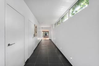 <p>Bent u op zoek naar een woning waar <span>wonen en werken</span> perfect gecombineerd kunnen worden? Of droomt u van een <span>kangoeroewoning</span> of een <span>ruime gezinswoning met tal van mogelijkheden</span>? Dan is deze uitzonderlijk ruime woning (438 m²) in het centrum van Maldegem precies wat u zoekt.</p>
<p>De woning geniet van een centrale ligging met alle voorzieningen op wandelafstand: winkels, scholen en openbaar vervoer bevinden zich in de onmiddellijke omgeving. Bovendien is er een vlotte verbinding naar zowel de kust als het binnenland.</p>
<p>Bij het betreden van het pand vallen meteen de twee afzonderlijke ingangen op: één naar de voormalige tandartsenpraktijk en één naar de privéwoning, met onderlinge doorgang tussen beide units.</p>
<p><strong>Via de eerste ingang</strong> bereikt u de praktijkruimte, bestaande uit een inkomhal met gastentoilet, een aparte berging, wachtruimte, bureauruimte en twee voormalige kabinetten. Deze ruimtes zijn uitgerust met airconditioning en lenen zich perfect voor een vrij beroep of kunnen ingericht worden als een volwaardige tweede woonunit.</p>
<p><strong>De tweede ingang</strong> leidt naar de ruime privéwoning. U komt binnen in een royale inkomhal met ingemaakte vestiairekasten en gastentoilet. De lichtrijke leefruimte omvat een gezellige eetplaats en woonkamer met open haard. Aansluitend bevindt zich de open keuken met extra eetruimte. Deze hoogwaardige Siematic-keuken is uitgerust met een natuurstenen werkblad, Amerikaanse koelkast met vriezer, gas- en inductiekookzones, Venduro dampkap, Miele inbouwfriteuse, extra brede oven, combi-oven en dubbele spoelbak. Verder is er een unieke inloopkoelcel voorzien in de hal, evenals een praktische wasplaats met ingemaakte kasten en extra bergruimte.</p>
<p>Op de <span>eerste verdieping</span> bevinden zich vijf volwaardige slaapkamers en twee badkamers, elk uitgerust met lavabo en douche. De <span>tweede verdieping</span> herbergt een prachtige master bedroom met ensuite badkamer voorzien van lavabo, bubbelbad, douche en toilet. Ook hier is airconditioning aanwezig voor optimaal comfort.</p>
<p>Daarnaast beschikt de woning over een praktische <span>kelder</span>.</p>
<p>Buiten geniet u van een gezellig, <span>ingesloten terras</span> dat rechtstreeks toegankelijk is vanuit de keuken. Achteraan bevindt zich een <span>ruime tuin met een groot aangelegd terras</span>, deels overdekt en voorzien van een open haard – ideaal om het hele jaar door te genieten. Verder zijn er meerdere tuinbergingen met extra zolderruimte en vaste trap.</p>
<p>Vooraan is er een <span>oprit</span> met plaats voor twee wagens. Bovendien bestaat de mogelijkheid om naast de woning een garage te huren met ruimte voor drie wagens.</p>
<p>Kortom: <span><strong>een veelzijdige eigendom met tal van mogelijkheden op een toplocatie in Maldegem.</strong></span><br /><br />Benieuwd naar de mogelijkheden? <br /><span>Contacteer Bonne Vastgoed 7 op 7 via 050/73.73.73 of info@bonnevastgoed.be</span></p>