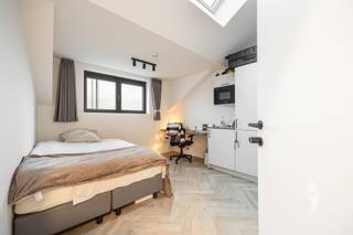 <p><span>Ontdek deze hedendaagse studentenkamer in een hoogwaardig renovatieproject, gelegen aan de Mechelsestraat 154, midden in het centrum van Leuven. Het gebouw werd volledig vernieuwd met oog voor duurzame materialen en voldoet aan alle moderne eisen op het vlak van comfort en energiezuinigheid.</span></p><p><span>De kamer bevindt zich op de 1ste verdieping en is voorzien van een energiezuinige lucht warmtepomp, die zorgt voor aangename verwarming in de winter en verkoeling tijdens de zomermaanden. Ze wordt volledig gemeubeld aangeboden en beschikt over een bed (zonder matras). Daarnaast heeft de kamer een eigen badkamer met douche, lavabo en toilet.</span></p><p><span>Bewoners kunnen gebruikmaken van een volledig uitgeruste gemeenschappelijke keuken. Bovendien is er een ruim terras én een grote tuin, ideaal om te ontspannen of samen tijd door te brengen in een groene omgeving. Ook is er een praktische fietsenberging voorzien.</span></p><p><span>Dankzij de centrale ligging zijn campussen, winkels en horecazaken vlot te voet bereikbaar, wat deze kamer tot een ideale uitvalsbasis maakt voor studenten.</span></p><p><span>De gebruikte foto's zijn afkomstig van gelijkaardige projecten en dienen als indicatie van de afwerking en sfeer.</span></p><p><span> </span></p>