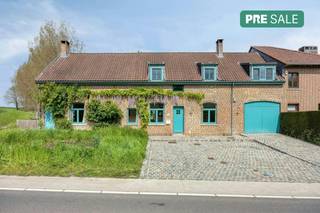 This unique long-facade farmhouse enjoys a quiet location next to a forest, just 15 minutes from Brussels. Nature lovers will be thrilled by the immediate proximity of the Zuun valley. This property offers the perfect balance between rural tranquility and excellent accessibility.The farmhouse has a living area of 320 m² on a generous 21.25-are plot. You have the option to purchase the adjacent, bio-certified land featuring around twenty fruit trees (91.60 ares). This brings the total area to 1.12 hectares. Additional assets include a groundwater well and a beautiful cobblestone driveway with space for four cars.On the ground floor, you will find a spacious entrance hall with a guest toilet and a room currently used as an office, which could easily serve as a bedroom. The bright kitchen features a large 110 cm gas stove, a scullery, and a storage room. The living room, with a beautiful fireplace and sliding doors to the large terrace, forms the heart of the home. The terrace provides access to a spacious studio. Furthermore, there is an indoor garage for one car.The first floor offers two very spacious bedrooms, each with an en-suite bathroom. A long hallway leads to two extra bedrooms, a third bathroom/laundry room, and a toilet. 9 Velux skylights bathe the entire floor in natural light, offering stunning views of the garden, woods, and fields. Seize this unique opportunity to own this beautiful domain.Register of measures: no