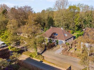 Woning in landelijke stijl met 5 slaapkamers en 2 badkamers, gelegen aan de Turnhoutse stadsrand en in een rustige, doodlopende straat, op een perceel van ca 1.132m². <br /><br />We betreden de woning via de inkomhal die open is tot in de nok, met daarin het gastentoilet met handenwasser. De leefruimte op parket met houthaard is ruim van opzet en geeft via grote deuren toegang tot het zonneterras en de tuin. De keuken is vernieuwd in 2014 en is voorzien van volgende toestellen: microgolfoven, oven (BJ 2026), inductie kookplaat, dampkap, vaatwasmachine (BJ 2023) en een koelkast. Aansluitend bevindt zich de praktische wasplaats met ingemaakte kasten. De garage is ruim genoeg voor 2 wagens achter elkaar. Hierin bevindt zich tevens de aardgasketel, praktische, ingemaakte kasten en een deur naar de tuin. Op het gelijkvloers is er tenslotte de hoofdslaapkamer en een badkamer voorzien van 2 wastafels, een inloopdouche en grote kasten. <br />Via de trap in de inkomhal komt u terecht in de vide op de 1e verdieping. Hier bevinden zich 4 slaapkamers en de kinder- of gastenbadkamer met toilet, douche en een enkele wastafel.<br /><br />De tuin is volledig aangelegd met volwassen beplanting, is omheind, en voorzien van een groot zonneterras met zonneluifel. Er is tenslotte een groot, houten tuinhuis.<br /><br />Buitengewone kenmerken:<br />* conforme elektrische keuring<br />* Een mooie troef is dat de tuin achteraan grenst aan bosgebied wat u zicht op het groen en absolute rust garandeert.<br />* Prachtig gelegen, net binnen de ring van Turnhout en op wandelafstand van de Nieuwe Kaai en alle voorzieningen.