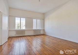 Op een centrale ligging, vlak bij het centrum van de stad, het stadspark, winkels, openbaar vervoer, het ziekenhuis en belangrijke invalswegen, bevindt zich dit mooi afgewerkte en zeer lichtrijke appartement.<br /><br />Bij het binnenkomen vallen de hoge plafonds en de uitzonderlijk royale ruimtes meteen op.<br />Met een bewoonbare oppervlakte van ca. 115 m² biedt dit appartement een aangenaam gevoel van ruimte.<br /><br />Via de beveiligde inkomdeur betreedt u de inkomhal, die toegang geeft tot een apart gastentoilet en een praktische berging/vestiaire. Deze is uitgerust met maatkasten en biedt onder meer plaats voor een wasmachine en droogkast.<br />De woonkamer geniet van veel lichtinal en is voorzien van prachtige authentieke houten vloeren. Aansluitend bevindt zich de keuken met ruimte voor een eettafel en hebt u toegang tot een aangenaam balkon waar u heerlijk van de avondzon kunt genieten.<br /><br />Verder zijn er 2 royale slaapkamers waarvan één met recent vernieuwde ensuite badkamer, uitgerust met een ligbad, aparte douche en een dubbele lavabo.<br /><br />Ook het gebouw zelf vormt een belangrijke troef: het werd recent gerenoveerd, beschikt over privatief gemeten nutsvoorzieningen en heeft lage gemeenschappelijke kosten.<br /><br />Kortom, een uitzonderlijk ruim en instapklaar appartement op een toplocatie – ideaal voor wie comfortabel wil wonen met alle voorzieningen binnen handbereik.<br /><br />Interesse? Contacteer ons snel voor een bezoek en ontdek zelf de troeven van dit charmante appartement!