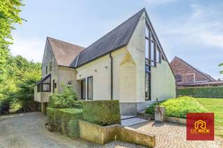 A beautifully situated villa with a unique garden and the Osbroek as its backyard, centrally located near the E40 with easy access to Brussels and Ghent, and close to supermarkets, shops, and the center of Aalst.The spacious detached home features, on the ground floor, an entry hall finished with high-quality natural stone, a very spacious and light-filled living room with an adjoining guest dining area, an open kitchen with dining area and an adjoining lounge, a utility room, a spacious home office, and a separate restroom with a sink.On the first