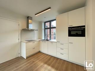 <br />In het centrum van Lochristi, verscholen tussen het groen, vindt u 1 van de mooiste parels van Lochristi. Het prachtig herenhuis op de hoek van de Burgemeester Vermeulenlaan en de N70 heeft een heuse renovatie ondergaan, met respect voor het historisch karakter.<br />Het pand is opgewaardeerd en voldoet volledig aan de hedendaagse normen met behoud van enkele prachtige authentieke elementen.<br />Op vandaag bestaat het herenhuis uit een handelsruimte op het gelijkvloers (huisartsenpraktijk) en 4 appartementen, waarvan dit appartement op de eerste verdieping, bereikbaar via lift of authentieke traphal.<br />Dit één slaapkamer appartementen dat eveneens geniet van een ruim terras (13m²) met mooi uitzicht.<br />Via de inkomhal heb je een apart toilet en daarna komt u in de ruime lichtrijke open keuken ingericht met kwalitatieve toestellen en deels afzonderlijke zitruimte. Het terras is toegankelijk via de zitruimte en slaapkamer met prachtig zicht op het groen.<br />Verder is er een ruime slaapkamer die toegang heeft naar de badkamer met inloopdouche en kast met lavabo en wasruimte.<br />Het E-peil van dit appartement is E50, deze is dan ook goed geïsoleerd en maakt gebruik van een warmtepomp.<br /><br />Dit luxueus appartement is volledig afgewerkt met verlichting én gordijnen.<br />Met andere woorden, een uniek, volledig instap klaar appartement in hartje Lochristi!<br /><br />Dit appartement geniet van een eigen autostaanplaats en daarnaast is er een fietsstalling voorzien.<br />Er is een lift aanwezig!<br /><br />Beschikbaar vanaf 1/11/2026<br /><br />Huurprijs: 960,00€ + 50,00€ alg kosten = 1010,00€/maand<br /><br />Interesse in dit appartement? Mail ons met uw naam EN telefoonnummer: info@loimmo.be<br />Wij contacteren U!