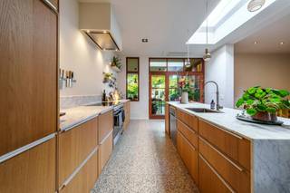 Achter de gevel van deze woning schuilt een zee aan ruimte en natuurlijk licht. Het huis werd door de jaren heen met veel passie gerenoveerd: authentieke details bleven bewaard, maar werden naadloos gecombineerd met modern wooncomfort. Een instapklare, warme gezinswoning die werkelijk alles afvinkt!<br /><br />Licht, sfeer en gezelligheid<br />Via de praktische inkomhal met vestiaire komt u binnen in de woning. Vooraan bevindt zich een apart bureau, de perfecte plek voor thuiswerk of als hobbyruimte. De ruime leefruimte pakt uit met hoge plafonds, een op maat gemaakte boekenkast en een knusse houtkachel. De grote leefkeuken vormt het kloppend hart van het huis: een fantastische plek om te koken, te eten en te genieten met familie of vrienden.<br /><br />Zuidwest-gerichte tuin &amp; geïsoleerde garage<br />De keuken vloeit mooi over in het zonnige terras met sfeerverlichting (instant vakantiegevoel!). In de zuidwest-gerichte tuin geniet u van de middag tot zonsondergang van de zon, met schaduw van de mooie bomen.<br />Een absolute troef is de recent gebouwde, volledig geïsoleerde garage met automatische poort (stijlvol afgewerkt in acaciahout). Via het achterpoortje heeft u bovendien directe toegang tot een ruime parking, de lagere school, sporthal en het cultureel centrum. Uw wagen kan dus gewoon blijven staan!<br /><br />Luxe badkamer &amp; slaapkamers<br />Op de bovenverdieping vindt u meerdere ruime slaapkamers, een apart toilet en de absolute eyecatcher van de woning: de recent vernieuwde, luxueuze badkamer. Deze badkamer is tot in de puntjes afgewerkt met naadloze Mortex, een eiken meubel, een bad en inloopdouche in solid surface, en prachtige gouden kranen (Philippe Starck voor Axor). Bovendien is er nog een ruime zolderverdieping die perfect dienst kan doen als extra slaapkamer, speelkamer of opbergruimte.<br /><br />De grootste troeven op een rij:<br /><br />Energiezuinig en modern: Voorzien van zonnepanelen, een lucht lucht warmtepomp(keuken en slaapkamer), hoogrendementsketel en waterverzachter.<br /><br />Regenwaterrecuperatie: Grote waterput aangesloten op toiletten en buitenkraan. (Ook is er al een gescheiden rioleringsstelsel voorzien).<br /><br />Praktische bergruimte: Ruime, droge kelder en een aparte wasplaats op het gelijkvloers.<br /><br />Toplocatie: Achteraan directe toegang tot scholen, sport en cultuur, inclusief ruime parking en eigen garage.<br /><br />Oase van licht: Overal grote raampartijen, in de badkamer geniet u 's ochtends in de douche van de opgaande zon.<br /><br /><br /><br /><br />Bestuursmaatregelen in het maatregelenregister: nee