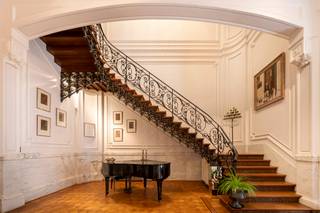 <p>Gelegen aan de befaamde Jan van Rijswijcklaan bevindt zich deze authentieke meesterwoning met conciergerie en garage.<br /><br />Uitzonderlijk brede gevel in Beaux-Art-stijl uit 1910. <br />De statige inkomhal met vestiaire leidt naar de verscheidene vertrekken van de woning.<br />Het ontvangstsalon en zitkamer heeft rijkelijk versierde hoge plafonds en origineel schrijnwerk. Vervolgens een salon met formele eetkamer in de erker met uitzicht op de tuin. De keuken is voorzien van de gebruikelijke toestellen.<br />De eerste verdieping is ingericht met royale masterslaapkamer en ensuite zéér comfortabele Italiaanse badkamer. Het bureau met ingemaakt kastenwerk kan tevens functioneren als bibliotheek.<br />De tweede verdieping, ook bereikbaar per lift, herbergt twee extra slaapkamers met eigen badkamer. Een derde kamer is momenteel speelkamer. Er is tevens een kitchenette voorzien.<br />De sous-terrain biedt een ontspanningsruimte met bar, fitnessruimte en wijnkelder. De technische berging en wasplaats bevinden zich eveneens op deze verdieping. <br />Via de tuin met verschillende terrassen heeft u toegang tot de achterliggende garages (4 autoplaatsen). Een bovenliggend appartement kan dienen als conciergerie of woonst voor een au-pair.</p>