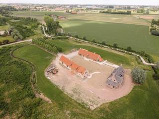 Aan de rand van Roeselare, waar rust en bereikbaarheid elkaar ontmoeten, ligt een domein dat zijn gelijke in de regio nauwelijks kent. Beverseaardeweg 102 is geen gewone eigendom, maar een uitzonderlijke woonsite met karakter en uitstraling.<br /><br />Geschiedenis herschreven in steen<br /><br />Deze plek draagt de naam *De Blauwe Toren*, een historisch domein dat reeds in 1546 werd vermeld als omwalde hoeve in de wezenboeken, gelegen aan de Kromme Beek. Die rijke geschiedenis vormde de basis voor een hedendaags nieuwbouwproject dat de grandeur van weleer herinterpreteert in een volledig nieuwe realisatie, afgewerkt volgens de hoogste normen van vandaag.<br /><br />Het domein – ca. 2 hectare exclusiviteit<br /><br />Achter de elektrische toegangspoort ontvouwt zich een uniek geheel. Een groene oprijlaan leidt naar het hart van het domein waar drie imposante gebouwen in een karakteristieke U-vorm de sfeer van een klassieke hoevesite oproepen. Het geheel wordt gekenmerkt door absolute rust en privacy, terwijl zowel het centrum van Roeselare als de belangrijkste invalswegen en autostrades vlot bereikbaar blijven.<br /><br />Het exclusieve domein beschikt over een totale bruikbare vloeroppervlakte van ca. 1.344 m² en werd vergund voor drie afzonderlijke gebouwen, wat het geheel een zeldzaam karakter geeft. De hoofdwoning is volledig onderkelderd en op het terrein is reeds een zwembad met aanhorigheden voorzien. Daarnaast zijn de grond- en rioleringswerken uitgevoerd en werden de omgevingswerken reeds gedeeltelijk aangelegd.<br /><br />De gebouwen<br /><br />A | Villa (casco – nog volledig naar eigen afwerking)<br />De hoofdwoning bevindt zich in ruwbouw en biedt op het gelijkvloers een ruime inkomhal met gastentoilet, een lichtrijke leefruimte met zit- en eethoek en haard, een open keuken en een mudroom. Op de verdieping bevinden zich vier volwaardige slaapkamers, drie badkamers en een apart toilet. De woning is volledig onderkelderd en biedt zo bijkomende mogelijkheden.<br /><br />B | Poolhouse / guesthouse (volledig afgewerkt)<br />Het rechter bijgebouw is instapklaar en vandaag ingericht als hoogwaardig gastenverblijf of entertainmentruimte. Het omvat een tv-hoek, open keuken met salon en eethoek, berging, technische ruimte en apart toilet. De blikvanger is de organisch gevormde bar die aansluit op een overdekt terras met buitenhaard. Boven De bovenverdieping biedt drie slaapkamers en twee badkamers en een polyvalente ruimte. Dit gebouw omvat een bruikbare oppervlakte van ca. 392 m².<br /><br />C | Multifunctioneel bijgebouw (functioneel en polyvalent)<br />Het linker bijgebouw combineert praktische functies met architecturale sterkte. Het beschikt over een garage voor drie wagens, fietsenberging en diverse bergingen. Daarnaast bevindt zich een indrukwekkende polyvalente zaal die tot in de nok reikt en wordt gekenmerkt door de authentieke baksteenstructuur en houten dakspanten. Afhankelijk van de bestemming biedt dit gebouw nog verdere invullingsmogelijkheden.<br /><br />D | Buitenruimte &amp; zwembad<br />De buitenruimte is reeds deels aangelegd en voorzien van een buitenzwembad van 4 op 15 meter, waarvan de infrastructuur klaar ligt voor verdere afwerking. De oprijlaan, bomenstructuur en groenzones versterken het besloten karakter van het domein.<br />Voor wie geen genoegen neemt met het gewone<br /><br />Dankzij de combinatie van een perceel van ruim 2 hectare, de drie vergunde gebouwen en de reeds gerealiseerde basisinfrastructuur biedt deze eigendom een zeldzame opportuniteit voor wie op zoek is naar een exclusieve woonsite met uitzonderlijke mogelijkheden.<br /><br />Exclusief. Zeldzaam. En niet te evenaren.<br /><br /><br />Bestuursmaatregelen in het maatregelenregister: in aanvraag