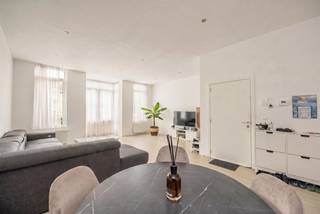 <p><span>Op zoek naar een ruim en instapklaar appartement op een supercentrale locatie? Dan zit je hier helemaal goed. Dit appartement combineert een grote, lichtrijke leefruimte met twee slaapkamers, een gezellig terrasje en een praktische indeling. Dankzij de hoge plafonds, het vele natuurlijke licht en de gunstige EPC-score, woon je hier bovendien bijzonder comfortabel.</span></p><p><span> </span></p><p><span>Licht, ruimte &amp; comfort</span></p><p><span>Via de verzorgde gemeenschappelijke inkomhal bereik je het appartement op de eerste verdieping. Je komt binnen in de ruime leefruimte met open keuken, waar het hoge plafond en de grote ramen meteen zorgen voor een heerlijk ruimtelijk gevoel. De combinatie van de lichte parketlaminaatvloer en erker in de leefruimte geven het  een warme, moderne uitstraling. Hier heb je meer dan genoeg plaats voor een gezellige zithoek, een grote eettafel én zelfs een thuiswerkplek.</span></p><p><span>De open keuken sluit mooi aan bij de leefruimte en is praktisch ingericht met een tegelvloer en een handige statafel voor extra comfort. Je beschikt over een ingebouwde oven, dampkap, fornuis, spoelbak en voldoende kastruimte. Dankzij de open indeling blijf je tijdens het koken altijd verbonden met je gasten of gezin.</span></p><p><span> </span></p><p><span>Rustige slaapkamers &amp; strak sanitair</span></p><p><span>Achteraan het appartement bevinden zich de twee slaapkamers, allebei rustig gelegen. De eerste slaapkamer kan perfect ingevuld worden naar eigen noden(slaapkamer, dressing,bureau) en  geeft rechtstreeks uit op het gezellige terrasje achteraan. Een fijne plek voor een koffietje in de ochtend of een apero na het werk. De tweede kamer is een volwaardige slaapkamer. De badkamer is strak en modern ingericht met een ruime douchecabine, lavabo met praktische onderkast en onderhoudsvriendelijke betegeling in zachte tinten. Verder heb je nog een apart gastentoilet met handenwasser én een technische ruimte met aansluiting voor was-droogmachine.  Veel spullen om op te bergen?  Er is nog een extra bergruimte voorzien in de kelder.</span></p><p><span> </span></p><p><span>Alles dichtbij in Deurne-Zuid</span></p><p><span>Je woont hier aan de Herentalsebaan vlakbij Deurne-Zuid, een buurt waar alles in de nabijheid ligt. Winkels, supermarkten, openbaar vervoer, de Zwitserse Apotheek en horeca bevinden zich op wandelafstand. Ook het Rivierenhof en Te Boelaarpark bereik je in enkele minuten, ideaal voor sport, ontspanning of een wandeling in het groen. Dankzij de nabijheid van de Ring en belangrijke invalswegen ben je bovendien snel onderweg naar het centrum of buiten de stad. Niet toevallig behaalt dit adres een uitstekende Mobiscore van 9,5/10.</span></p><p><span> </span></p><p><span>Maatregelenregister: in aanvraag</span></p><p><span> </span></p>