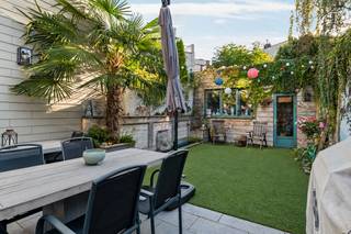 Welkom in deze verrassend ruime en volledig gerenoveerde (2017) woning, gelegen in de gezellige Groenenhoek, een geliefde en gezinsvriendelijke woonwijk in Berchem. Hier geniet u van een rustige, gemoedelijke buurt met alle voordelen van het stadsleven binnen handbereik.<br />De ligging combineert een aangename woonomgeving met een uitstekende bereikbaarheid. Scholen, buurtwinkels, supermarkten en openbaar vervoer bevinden zich vlakbij, terwijl ook het centrum van Antwerpen en de belangrijkste invalswegen vlot bereikbaar zijn. Voor een ontspannende wandeling of een moment in het groen liggen het Boekenbergpark en het Brilschanspark op korte afstand.<br /><br />Deze voormalige bakkerij werd in 2017 grondig gerenoveerd en omgevormd tot een comfortabele, energiezuinige woning waar ruimte, hedendaagse technieken en een praktische indeling centraal staan.<br /><br />Indeling van de woning:<br />Via de inkomhal met vestiaire en gastentoilet betreedt u de woning. Hier bevindt zich eveneens de ruime personenlift, die het gelijkvloers met de twee bovenliggende verdiepingen verbindt en zo extra comfort biedt voor personen met een beperkte mobiliteit.<br />De royale leefruimte is opgedeeld in een gezellige tv-hoek aan de voorzijde en een ruime eetkamer met aansluitend de open leefkeuken achteraan.<br />De keuken vormt het hart van de woning en is uitgerust met talrijke opbergkasten en alle nodige toestellen. Een echte blikvanger is het vijfpits inductiefornuis met verschillende ovens en een warmhoudvak. In de bergkasten zijn bovendien aansluitingen voorzien voor een wasmachine en droogkast.<br />Vanuit de eetkamer en keuken geniet u van een aangename verbinding met de stadstuin, die via de leefruimte rechtstreeks toegankelijk is.<br /><br />Eerste verdieping:<br />Op de eerste verdieping bevinden zich twee ruime slaapkamers.<br />De slaapkamer aan de achterzijde beschikt over een eigen dressing en toegang tot een aangenaam terras. De tweede slaapkamer is eveneens ruim en beschikt over een praktische bergruimte.<br />De comfortabele badkamer is uitgerust met een luxueus jetstreambad, een grote inloopdouche en een badkamermeubel. Op de nachthal bevindt zich een afzonderlijk toilet.<br /><br />Tweede verdieping:<br />Via de trap of lift bereikt u de tweede verdieping, waar zich nog eens twee ruime kamers bevinden.<br />De grootste kamer, gelegen aan de achterzijde, biedt verschillende mogelijkheden. Dankzij de reeds aanwezige aansluitingen kan hier een tweede badkamer of zelfs een kitchenette worden ingericht. Bovendien bestaat de mogelijkheid om een ruim terras te creëren.<br />De vierde slaapkamer bevindt zich aan de voorzijde.<br />Deze verdieping leent zich uitstekend voor opgroeiende kinderen, een thuiswerkplek of een meer zelfstandige woonruimte voor een inwonend familielid.<br /><br />Buitenruimte:<br />De zuidoostgerichte stadstuin vormt een aangename plek om in alle rust van het buitenleven te genieten.<br />Het terras van ca. 20 m² biedt voldoende ruimte voor een gezellige lounge- of eethoek. De fraaie muurbekleding creëert een verrassend gevoel van diepte en een panoramische uitstraling.<br />Achteraan bevindt zich bovendien een praktisch tuinhuis voor extra bergruimte.<br /><br />Kelder:<br />De woning is volledig onderkelderd. Via een doorgang onder de trap bereikt u de droge kelderverdieping, waar zich de nutsmeters en technische installaties bevinden. Daarnaast biedt deze verdieping bijzonder veel opslagruimte.<br />Parkeren: <br />Dit kan op de openbare parkeerplaatsen in de straat. Bovendien bestaat de mogelijkheid om de huurovereenkomst van een nabijgelegen garagebox over te nemen.<br /><br />Troeven van de woning:<br />- Volledig gerenoveerd in 2017, inclusief energetische verbeteringen<br />- Vier ruime slaapkamers<br />- Personenlift van het gelijkvloers tot de tweede verdieping<br />- Geschikt voor personen met een beperkte mobiliteit<br />- Uitstekend energiezuinig A-label<br />- 18 zonnepanelen met certificaten<br />- Volledig geïsoleerde gebouwschil<br />- Vloerverwarming en condensatieketel<br />- Domoticasysteem voor extra comfort<br />- Royale leefruimte met open leefkeuken<br />- Luxueuze badkamer met jetstreambad en inloopdouche<br />- Mogelijkheid tot tweede badkamer of kitchenette<br />- Zuidoostgerichte stadstuin met terras<br />- Volledig onderkelderd<br />- Mogelijkheden voor kangoeroewonen, onder voorbehoud van de nodige stedenbouwkundige toelatingen<br />- Rustige en centrale ligging in de Groenenhoek<br /><br />Kortom:<br />Deze woning biedt veel meer dan een klassieke gezinswoning. De combinatie van vier slaapkamers, een lift over alle verdiepingen, een hoogwaardige energetische renovatie en een aangename stadstuin maakt dit pand bijzonder veelzijdig.<br />Ideaal voor gezinnen die ruimte en comfort zoeken, maar ook voor wie levensloopbestendig wil wonen of verschillende generaties onder één dak wil samenbrengen.<br />Een instapklare en toekomstgerichte woning waar energiezuinigheid, ruimte en wooncomfort perfect samenkomen. <br /><br />Overtuig uzelf tijdens een bezoek ter plaatse!