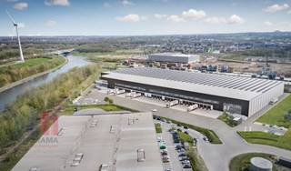 <strong>Logistiek magazijn </strong>binnen een nieuw project met 12.053 m² opslagruimte, 1.174 m² kantoorruimte en 2.297 m² mezzanine te huur.<br /><br />De site beschikt over een rechtstreekse trimodale toegang (water, spoor en weg). Dankzij de vlotte aansluiting op de E42 (1 km) en de E19 (4 km), evenals de nabijheid van de luchthavens van Charleroi, Brussel en Luik, geniet de locatie van een uitstekende nationale en internationale bereikbaarheid.<br /><br />De unit heeft een <strong>vrije hoogte van 13,7 m </strong>en een vloerbelasting tot 50 kN/m². De betonnen plint van 2,50 m en de ruime manoeuvreerruimte van 40 m garanderen een vlotte logistieke afhandeling, een<strong> sectionale poort (4 x 6 m) </strong>en laad- en loskades met nivelleerder (1 per 1.000 m²), wat een efficiënte goederenstroom mogelijk maakt.<br /><br />Verder biedt het gebouw een hoog comfort- en veiligheidsniveau met airconditioning, LED-verlichting (200–250 lux en 250–500 lux), een hoogspanningscabine van 400 kVA, een elektrisch bediende slagboom en ruime autoparkeerplaatsen. Op het vlak van brandveiligheid is de unit uitgerust met ESFR-sprinklers, branddetectie, een brandalarmsysteem en brandslangenhaspels.<br /><br />Contacteer<strong> PANORAMA B2B</strong> voor bijkomende informatie, plannen of een vrijblijvend plaatsbezoek <strong>0479 70 70 70</strong><br />