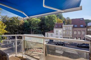 Op een uitstekende ligging aan het prachtige Rivierenhof bevindt zich dit verzorgd appartement (bouwjaar 1995) met rechtstreeks zicht op het park. Dankzij de gunstige oriëntatie geniet u hier van een aangename lichtinval en een rustige woonomgeving, terwijl alle voorzieningen zich in de nabije omgeving bevinden.<br /><br />Het appartement beschikt over een zonovergoten leefruimte met aansluitend de keuken. Vanuit de leefruimte heeft u rechtstreeks toegang tot het terras, waar u comfortabel een tafel en stoelen kan plaatsen om te genieten van het buitenleven.<br /><br />De keuken is volledig ingericht en voorzien van alle comfort, waaronder een kookplaat, dampkap, oven, koelkast, afwasmachine en voldoende opbergkasten. Aansluitend bevindt zich een praktische berging.<br /><br />Verder beschikt het appartement over een apart gastentoilet en een ruime badkamer uitgerust met een douche, ligbad, dubbele wastafel en de aansluitingen van wasmachine en droogkast. Er zijn twee volwaardige slaapkamers waarvan één is ingericht met ingebouwde kast beide slaapkamers geven bovendien toegang tot het terras aan de achterzijde.<br /><br />Alle nutsvoorzieningen (water, gas en elektriciteit) zijn individueel. Het gebouw beschikt over een lift.<br /><br />Tot slot is er de mogelijkheid om een garagebox in het gebouw aan te kopen als supplement. (€30.000)<br /><br />Een ideaal appartement voor wie comfortabel wil wonen op een groene en gegeerde locatie nabij het Rivierenhof.<br /><br />Voor meer informatie of een bezoek ter plaatse, contacteer ons zo snel mogelijk!
