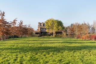 <br />In een uitzonderlijke groene omgeving, op een royaal perceel van 4.351 m², bevindt zich deze architecturale villa, ontworpen door Jos Van Driessche en opgetrokken in 2009. De invloed van Frank Lloyd Wright is duidelijk aanwezig in de horizontale lijnen, de open zichten en de harmonieuze inpassing in het landschap. Dit is een woning die niet alleen indruk maakt door haar immense ruimte, maar ook door haar unieke architecturale signatuur.<br /><br />Met een bewoonbare oppervlakte van 650 m² en een volledig bruikbare kelderverdieping van 304 m² biedt deze villa een uitzonderlijk wooncomfort. De inkomhal met gastentoilet leidt naar een aparte bureauruimte, twee ruime leefruimtes, een lichtrijke eetplaats en een volledig uitgeruste keuken. Daarnaast is er een praktische wasruimte en een dubbele garage.<br /><br />De woning beschikt over vier volwaardige slaapkamers en twee badkamers op de eerste verdieping. Verder kan u genieten van een aparte ruimte waar een sauna en douche is voorzien. De tweede verdieping biedt op heden een vijfde slaapkamer en bijkomende mogelijkheden voor extra kamers of een hobbyruimte.<br /><br />De volledige woning is voorzien van twee trappen aan beide zijden van de woning wat ervoor zorgt dat de woning tevens kan dienen als kangoeroewoning.<br /><br />Wat deze woning écht uniek maakt, zijn de onvervalste vergezichten op het omliggende groen en het beschermd zicht op de Schelderomolen, wat zorgt voor een blijvend gevoel van ruimte en rust doorheen de woning en de tuin. Maak de tuin compleet met een zwembad waardoor u in de zomerperiode kan genieten van vakantie in eigen land. De hoogwaardige materialen, de zorgvuldig uitgevoerde details en de uitzonderlijke architectuur tillen deze villa naar een niveau dat zelden op de markt komt.