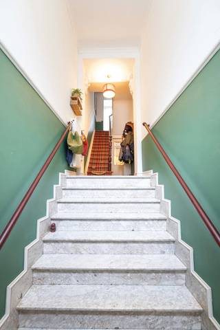 <p>Op wandelafstand van het Josaphatpark, in een gegeerde en rustige woonwijk van Schaarbeek, ontdekt u deze karaktervolle woning van ±222 m² met een prachtige gevel begroeid met groen.<br /><br />De woning combineert authentieke charme met hedendaags comfort dankzij haar hoge plafonds, originele moulures, massieve houten vloeren en de grondige renovatie die grotendeels in 2008 werd uitgevoerd.<br /><br />De lichtrijke leefruimte van ±30 m² met functionele open haard vormt het hart van de woning, aangevuld met een gezellige keuken en een aangenaam terras. Op het tuinniveau bevinden zich twee polyvalente ruimtes die ideaal zijn als bureau, speelkamer, tweede salon of onafhankelijke woonruimte dankzij het potentieel voor een extra keuken en badkamer.<br /><br />De woning beschikt verder over vier slaapkamers, twee badkamers, een zolder en verschillende buitenruimtes, waaronder een koer, terras en balkon. Het nabijgelegen Josaphatpark vormt een natuurlijke verlenging van uw leefomgeving. Conforme elektriciteit, recente Bosch condensatieketel, vernieuwd en geïsoleerd dak, dubbele beglazing, stedenbouwkundig in orde en EPC E.<br /><br />Een unieke gezinswoning met karakter, ruimte en tal van mogelijkheden.</p>
<p><u>Tuinniveau</u> :</p>
<ul>
<li>Veelzijdige ruimte van ±30 m² bestaande uit twee aaneengesloten kamers, momenteel ingericht als kantoren</li>
<li>Hal met diensttrap die rechtstreeks toegang geeft tot de keuken</li>
<li>Oude kolenkelder met behoud van de oorspronkelijke charme</li>
<li>Wasruimte die gerenoveerd moet worden, met potentieel voor inrichting als tweede keuken en/of badkamer</li>
<li>Privétuin van ±7,5 m²</li>
<li>Vloer volledig gerenoveerd en geïsoleerd tussen het tuinniveau en de begane grond</li>
</ul>
<p><u>1e tussenverdieping</u>: Toilet met wastafel & terras van ±3,5 m²</p>
<p><span>Begane grond:</span></p>
<ul>
<li>Entreehal</li>
<li>Lichte woonkamer van ±30 m² met massief parket en functionele open haard</li>
<li>Ingerichte keuken met toegang tot de buitenruimtes</li>
</ul>
<p><u>1e verdieping</u>:</p>
<ul>
<li>Slaapkamer aan de voorzijde van ±15 m² met toegang tot het balkon van ±1,5 m²</li>
<li>Slaapkamer aan de achterzijde van ±13,5 m²</li>
<li>Badkamer van ±5 m² (bad, wastafel)</li>
</ul>
<p><u>2e tussenverdieping</u>: toilet met wastafel</p>
<p><u>2e verdieping</u>:</p>
<ul>
<li>Slaapkamer aan de voorzijde van ±15 m²</li>
<li>Slaapkamer aan de achterzijde van ±14 m²</li>
<li>Doucheruimte van ±5 m²</li>
<li>Toegang tot de zolder</li>
</ul>
<p><u>Zolder</u>: extra opslagruimte<br /><br /><span>Pluspunten:</span><br />• Karakteristieke woning in Schaerbeek met een bewoonbare oppervlakte van ±222 m²<br />• Prachtige, met groen begroeide voorgevel<br />• Authentieke charme: hoge plafonds, historische sierlijsten en massief houten parket<br />• Grondige renovatie uitgevoerd in 2008<br />• Uitstekende algemene staat van onderhoud<br /><br /><span>Technische kenmerken:</span><br />• Elektriciteit conform de voorschriften<br />• Recente Bosch-gascondensatieketel<br />• Houten kozijnen met dubbele beglazing<br />• Dak onlangs vernieuwd en geïsoleerd<br />• EPC E<br />• Stedenbouwkundig in orde<br /><br /><br /></p>