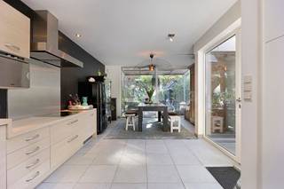<p><strong>Halfopen woning met 3 slaapkamers, ruime tuin, garage en uniek tiny house nabij de Kalmthoutse Heide.</strong><span></span></p>
<p>Midden in het groen en vlak bij de prachtige Kalmthoutse Heide ligt deze charmante halfopen woning met een bewoonbare oppervlakte van ca. 148 m² op een perceel van ca. 800 m². Een woning die niet alleen veel wooncomfort biedt, maar dankzij de ruime tuin, garage en het aanwezige tiny house ook bijzonder veelzijdig is.</p>
<p>De woning ligt wat verder naar achteren op het perceel en is bereikbaar via 2 toegangspoorten. Aan de voorzijde is er een ruime oprit met plaats voor 2 wagens en een oplaadpunt voor een elektrische auto. Hier bevindt zich ook een tuinhuis dat uitstekend dienst kan doen als fietsenberging. Naast de woning staat een aparte garage met bijkomende berging.</p>
<p>Binnen word je verwelkomd in de inkomhal met ingemaakte vestiairekast. De gezellige leefruimte is afgewerkt met parket en sluit aan op een aparte bibliotheek. Dankzij de schuifdeur kan deze ruimte volledig worden afgesloten, waardoor ze ook interessant is als rustige werk- of hobbyruimte.</p>
<p>Verder bevinden zich op het gelijkvloers een gastentoilet en een praktische berging met aansluiting voor de wasmachine en de technieken.</p>
<p>Het hart van de woning is de ruime leefkeuken met eethoek en pelletkachel. De keuken is voorzien van een grote kookplaat met dampkap, vaatwasser, anderhalve spoelbak, stoomoven, microgolfoven, oven en koelkast. Via een schuifdeur stap je vanuit de leefkeuken rechtstreeks de tuin in. De achterinkom wordt momenteel als hoofdingang gebruikt.</p>
<p>Via de trap in de hal bereik je de eerste verdieping. Hier bevinden zich 3 slaapkamers en de badkamer. Eén slaapkamer is momenteel ingericht als dressing, maar kan perfect opnieuw als slaapkamer worden gebruikt. De hoofdslaapkamer beschikt over ingebouwde kasten. De badkamer is ruim uitgerust met een bad, aparte douche, toilet en dubbele lavabo met meubel.</p>
<p>Ook buiten heeft deze woning heel wat te bieden. De tuin is volledig omheind en achter de woning zijn 2 gezellige terrassen aangelegd. Een absolute blikvanger is het tiny house in de tuin. Dit wordt momenteel gebruikt als extra werkplek. Er is bovendien ruimte voorzien voor het plaatsen van een toilet, douche en lavabo, waardoor het tiny house verschillende gebruiksmogelijkheden biedt.</p>
<p>Ook op technisch vlak zijn er interessante troeven. De woning wordt verwarmd op aardgas via radiatoren en in de keuken is aanvullend een pelletkachel aanwezig. In 2023 werd een Bosch 7000i 35C condensatieketel geplaatst. Het schrijnwerk op het gelijkvloers werd in 2020 vernieuwd en uitgevoerd in PVC. Daarnaast zijn er 7 zonnepanelen en een elektrisch oplaadpunt aanwezig.</p>
<p>Een woning voor wie houdt van groen, ruimte en flexibiliteit, met de Kalmthoutse Heide vlakbij en extra mogelijkheden dankzij de garage, ruime tuin en het bijzondere tiny house.</p>
<p>BEZOEKMOMENT: zaterdag 10 oktober tussen 10u en 12u (na afspraak).<br />Voor meer info of een bezoek te plannen, surf naar www.putsesteenweg61.be!</p>
