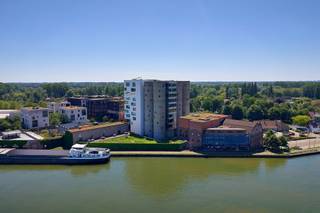 Exclusief appartement in de iconische Silo's van Het Kanaal<br /><br />In het prestigieuze woonproject Het Kanaal, de internationaal gerenommeerde herontwikkeling van Axel Vervoordt aan het Albertkanaal, bieden wij een uitzonderlijk appartement aan in de iconische Silo's. Deze unieke residentie maakt deel uit van een architecturaal meesterwerk waar industrieel erfgoed, hedendaagse architectuur, kunst en natuur harmonieus samenkomen. Het Kanaal groeide uit tot een culturele en residentiële bestemming van internationale allure, ontworpen rond de visie van Axel Vervoordt en gerealiseerd door onder meer architect Stéphane Beel.<br /><br />Gelegen op de derde verdieping, geniet dit appartement van een prachtig uitzicht over het Albertkanaal en de zorgvuldig aangelegde omgeving van Het Kanaal. De woning beschikt over een royale leefruimte met grote raampartijen die zorgen voor een uitzonderlijke lichtinval en een directe connectie met het water en het omliggende landschap.<br /><br />Het appartement omvat:<br /><br />2 ruime slaapkamers<br />2 volwaardige badkamers<br />Een elegant inpandig terras met zicht op het kanaal<br />Hoogwaardige afwerking en tijdloze architectuur<br />Een unieke woonbeleving binnen een van de meest gegeerde residentiële projecten van België<br /><br />Wonen in de Silo's betekent deel uitmaken van een exclusieve gemeenschap waar architectuur, kunst en levenskwaliteit centraal staan. Op de site bevinden zich onder meer galerijen, tentoonstellingsruimtes en zorgvuldig geïntegreerde groene zones die Het Kanaal een uitzonderlijk karakter geven. Prijs staanplaats en berging in de kelderverdieping. (€25.000 en €15.000).