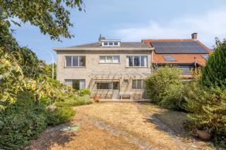 Deze ruim ingedeelde woning met vier slaapkamers bevindt zich op een hoekperceel van 338m², gelegen nabij het centrum.<br /><br />De inkomhal geeft toegang tot zowel de lichtrijke woning met parket, als tot de keuken met achterinkom en toegang tot de royale kelder met aangrenzende kruipruimte.<br />Aansluitend bij de keuken treffen we de berging/wasruimte met apart toilet en bijkomende achteringang, alsook de inpandige garage.<br /><br />Op de verdieping bevinden zich de vier volwaardige slaapkamers, de badkamer met ligbad, toilet en lavabo, en is er via een vaste trap toegang tot de zolder.<br /><br />De tuin is omheind d.m.v. een schutting en deels door struikgewas, en biedt de mogelijkheid om het eigendom via de achterzijde te betreden.<br />Voor de woning is er eveneens openbare parkeergelegenheid en bevindt er zich vlakbij een bushalte.<br /><br />Specificaties:<br />- c.v. op aardgas - Vaillant gaswandketel (2020)<br />- EPC: E-label - 454 kWh/(m² jaar)