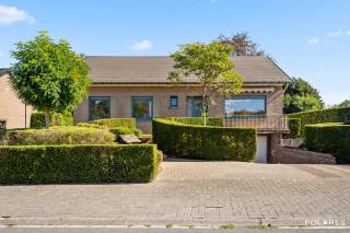 Bezoekmoment woensdag 14/10, plan uw bezoek via www.polares.eu<br /><br />In de Banhagestraat in Blanden ontdek je deze ruime woning met een bewoonbare oppervlakte (kelder inbegrepen) van 268 m², gelegen op een mooi perceel van 11a 64ca. <br />De rustige, residentiële ligging combineert groen wonen met een vlotte bereikbaarheid van Leuven, de E40, het Research Park Haasrode en de Brabantse Wouden (op wandelafstand).<br /><br />Via de ruime inkomhal met ingebouwde vestiairekasten en gastentoilet bereik je de royale woon- en eetkamer. Grote raampartijen aan beide zijden zorgen voor veel natuurlijk licht en een aangenaam zicht op de groene omgeving. Er is ruimschoots plaats voor een comfortabele zithoek en grote eettafel.<br />Aansluitend bevindt zich de functionele keuken met toegang tot de ruime veranda. Dankzij de kamerbrede beglazing vormt deze een aangename extra leefruimte met een mooie verbinding naar de tuin.<br /><br />Alle belangrijke woonfuncties bevinden zich op het gelijkvloers. De woning beschikt over drie slaapkamers en een recent vernieuwde badkamer met ruime inloopdouche en badkamermeubel.<br />Ook aan praktische ruimte is er geen gebrek. De woning is volledig onderkelderd en beschikt onder meer over een grote inpandige garage, wasruimte, technische ruimte en verschillende bergmogelijkheden. De kelderverdieping is bovendien rechtstreeks bereikbaar via de oprit via de garagepoort én via een extra ingang aan de tuinzijde. Daarnaast biedt de grote zolder nog heel wat extra bergruimte.<br />Buiten vormt de ruime en verzorgde tuin een absolute troef. Volwassen bomen, hagen, een groot gazon en verschillende terrassen creëren een groene en rustige omgeving met veel privacy.<br />De woning werd doorheen de jaren goed onderhouden en op verschillende punten vernieuwd, terwijl er nog mogelijkheden zijn om ze verder naar eigen smaak te moderniseren. Bovendien geldt er geen renovatieverplichting.<br />Kortom: een verrassend ruime woning met drie slaapkamers, vernieuwde badkamer, veranda, grote kelder met garage, ruime zolder en een prachtige tuin, op een rustige locatie met een uitstekende verbinding naar Leuven en de E40.
