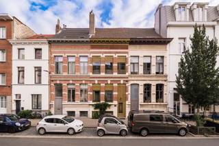 Klaar om deel uit te maken van het prachtige Antwerpen-Zuid?
Indeling
Bij het binnenkomen word je verwelkomd in een stijlvolle inkomhal met een prachtige trap die meteen de toon zet voor de rest van de woning.
Via een kleine trap bereik je het souterrain, waar een ruime leefkeuken werd ingericht. De keuken is uitgerust met een groot kookeiland, kwalitatieve toestellen en veel bergruimte — ideaal voor wie houdt van gezellig tafelen en koken. Dankzij het grote raam krijg je toegang tot een aangename stadstuin die uitnodigt tot ontspannen momenten in alle privacy. Daarnaast is er een handige kelderruimte die extra opslag biedt.
Op de eerste verdieping bevindt zich de ruime woonkamer die de volledige verdieping inneemt. Grote ramen zorgen voor overvloedig daglicht, terwijl de hoge plafonds en originele details zorgen voor een warme, uitnodigende sfeer.
De tweede verdieping herbergt een stijlvolle badkamer, voorzien van een inloopdouche, lavabomeubel en toilet. Daarnaast bevindt zich hier een flexibele ruimte, momenteel ingericht als bureau en zithoek, maar die ook kan worden omgevormd tot extra slaapkamers.
De bovenste verdieping is volledig gewijd aan de master bedroom.
Troeven
Karaktervolle woning met authentieke uitstraling
Zorgvuldig gerenoveerd met aandacht voor detail
Airconditioning op elke verdieping
Aangename stadstuin/koer met privacy