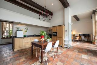 Charmant appartement in historisch 16de eeuws pand met stadstuin.<br />De grote poortdeur geeft toegang tot de gemeenschappelijke stadstuin waarlangs u naar de voordeur van het eigendom loopt. Rustig en privé gelegen in het centrum van de stad. <br />Uitzonderlijke leefruimte met open haard, hoge plafonds en veel lichtinval. De leefkeuken is voorzien van alle gebruikelijke toestellen. Via de leefruimte of de keuken bereikt men een gezellige private binnentuin. <br />De hoofdslaapkamer met ingemaakte kasten en een badkamer voorzien van dubbele wastafel, bad, douche en toilet. De tweede slaapkamer is voorzien ingemaakte kasten en een badkamer met wastafel, bad en toilet.<br />Dit appartement beschikt over een kelder. Een autostaanplaats wordt te koop aangeboden in combinatie met het appartement voor 40.000 euro.