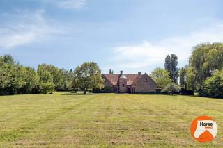 <p><strong>ROESELARE – Unieke villa met bijgebouwen op 4,7 ha<br /></strong>EERSTE BEZOEKDAG ZATERDAG 20/06 VAN 10U TOT 12U (enkel op afspraak!)<strong> </strong></p>
<p>Te midden van een uitgestrekt groen landschap, volledig omringd door eigen gronden en gelegen in agrarisch gebied, bevindt zich deze uitzonderlijke landbouwwoning op een uniek domein van maar liefst 46.905 m². Hier geniet u van absolute rust, maximale privacy en een ongeëvenaard gevoel van vrijheid, terwijl het panoramische uitzicht op de omliggende natuur elke dag opnieuw voor een bijzondere woonbeleving zorgt.</p>
<p>Deze stijlvolle woning werd gebouwd in 1992 met hoogwaardige en duurzame materialen en beschikt over een indrukwekkende bewoonbare oppervlakte van 454 m². Dankzij de grote raampartijen geniet elke ruimte van een overvloed aan natuurlijk licht en een prachtige connectie met het omliggende landschap. Bij het betreden van de woning wordt u verwelkomd in een inkomhal met gastentoilet.</p>
<p>De royale woonkamer vormt het hart van de woning en straalt tijdloze elegantie uit dankzij de authentieke vloeren in Franse witsteen. De open haard met inbouwkachel creëert een warme en gezellige sfeer, terwijl het unieke uitzicht over de eigen gronden een permanent gevoel van rust en exclusiviteit biedt. Aansluitend bevindt zich de volledig ingerichte keuken met centraal eiland. Verder beschikt de woning over een ruime afzonderlijke eetplaats en een bureau aan de inkomzijde, bijzonder geschikt voor wie professioneel klanten wenst te ontvangen of comfortabel van thuis uit werkt. Praktische ruimtes zoals een wasplaats, technische ruimte en dubbele garage vervolledigen het gelijkvloers.</p>
<p>Op de verdieping bevinden zich drie ruime slaapkamers, waaronder een master bedroom met ensuite dressing. De badkamer is uitgerust met een douche, ligbad, dubbele lavabo en toilet. Daarnaast werd extra aandacht besteed aan comfort met een afzonderlijk toilet en een ruime berging die eenvoudig kan worden ingericht als vierde slaapkamer. Vanuit de verschillende balkons geniet u van een uitzonderlijk vergezicht over het eigen domein en de omliggende natuur.</p>
<p>Het exclusieve karakter van deze eigendom wordt verder versterkt door de aanwezigheid van een opslagplaats, een stalling, een geboorde put (150m diepte), een idyllisch gelegen vijver en een prachtige afwisseling van weilanden en boomgaard. Het geheel vormt een zeldzame combinatie van luxe, ruimte en natuur op een van de meest unieke locaties in de regio.</p>
<p>Een uitzonderlijke eigendom voor wie op zoek is naar exclusief wonen in alle rust, omgeven door groen en met eindeloze mogelijkheden op een domein van bijna 4,7 hectare. Voor een afspraal contacteer ons: 053/60.65.66.<br /><br />De vermelde prijs is een richtprijs. Na ontvangst van de biedingen zal de verkoper beslissen of hij/zij de eigendom verkoopt aan het beste bod. De richtprijs is aldus niet bindend voor de verkoper. Voor meer info kunt u ons contacteren of het reglement raadplegen op onze website.</p>