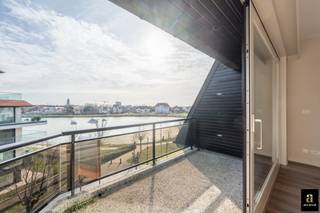 Ruim en zonnig appartement met panoramisch zicht op het Zegemeer, gelegen in de villa-residentie Maracana. Mogelijkheid tot aankoop van een ruime garagebox in het gebouw.<br />De inkomhal is voorzien van een vestiaire en gastentoilet. De ruime leefruimte, bestaande uit een salon en eetplaats, opent naar het zuidwest-gericht terras en biedt een adembenemend uitzicht over het Zegemeer. De volledig geïnstalleerde open keuken is uitgerust met alle hedendaagse comfort en toestellen, aansluitend praktische berging/wasplaats. De master bedroom beschikt over een en-suite badkamer met ligbad, dubbele lavabo en toilet. Daarnaast zijn er twee volwaardige slaapkamers en een bijkomende douchekamer. Alle slaapkamers geven rechtstreeks uit op het zonnige terras, waar u in alle rust kunt genieten van de avondzon. Mogelijkheid tot aankoop van een garagebox (anderhalve wagen diep) in de residentie, bereikbaar via het Georginapad. Verder zijn er twee privatieve kelders en een exclusief gebruiksrecht van het dakterras/solarium van 75 m². Gemeenschappelijke fietsenberging.