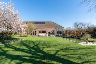 <h2><span>Deze prachtige vierkantshoeve te koop is gelegen op een ruim perceel van 26a69 in een rustige en groene omgeving in Bilzen.</span></h2>
Sommige woningen bieden meer dan enkel ruimte – ze bieden een gevoel.<br />Deze prachtige vierkantshoeve is zo’n plek waar charme, authenticiteit, rust en volledig privacy samenkomen.<br /><br />Van zodra je de hoeve binnenstapt, ervaar je een bijzonder gevoel van openheid en sereniteit.<br />De combinatie van authentieke materialen, warme houtstructuren, hoge plafonds en overvloedige lichtinval creëert een unieke woonbeleving.<br />Grote raampartijen verbinden binnen en buiten en bieden een prachtig zicht op de binnenkoer, op de achterliggende tuin en de omliggende weilanden.<br /><br />Deze eigendom biedt bovendien een uitzonderlijk potentieel. Dankzij de royale volumes en veelzijdige indeling kan deze hoeve volledig worden afgestemd op uiteenlopende woonwensen en levensstijlen.<br /><br />Een bijzondere troef is het aparte woongedeelte aan de voorzijde met leefruimte, keuken, slaapkamer en badkamer. Deze ruimte kan perfect worden gebruikt als kangoeroewoning of gastenverblijf of aangepast worden naar kantoor of praktijkruimte.<br /><br />De ligging combineert het beste van twee werelden: landelijke rust en privacy terwijl je toch geniet van een vlotte bereikbaarheid dankzij de nabijheid van de autosnelweg en is het historische Alden Biesen vlakbij.<br /><br /><strong>INDELING</strong><br />Bij het betreden van de woning kom je terecht in een imposante leefruimte met een indrukwekkend hoog plafond, warme houten accenten en een centrale houtkachel die het hart van de woning vormt.<br />Aansluitend bevindt zich een verhoogd zitgedeelte, ideaal als gezellige lees- of ontspanningsruimte.<br /><br />De leefruimte loopt naadloos over in de zomerleefruimte met eetruimte en verhoogde zithoek, waar binnen- en buitenleven op een natuurlijke manier samenkomen.<br />De keuken met kookeiland vormt een perfecte balans tussen hedendaags comfort en authentieke charme. Het gewelfde bakstenen plafond geeft deze ruimte een bijzonder karakter.<br />Daarnaast is er een praktijkruimte, volledig afgescheiden van zowel het extra woongedeelte aan de voorzijde als het hoofdvolume van de hoeve.<br /><br /><strong>VERDIEPING</strong><br />Op de verdieping bevinden zich vier slaapkamers, waaronder een ruime masterbedroom<br />met badkamer en dressing.<br />De overige 3 slaapkamers delen een tweede badkamer en beschikken eveneens over maatkasten en een dressing.<br /><br /><strong>BUITENRUIMTE</strong><br />De sfeervolle binnentuin met terras en open haard vormt een intieme plek waar je in alle rust kan genieten.<br />Aan de achterzijde strekt zich een prachtige tuin uit met verwarmde zwemvijver en een weids uitzicht over de omliggende velden zonder enige inkijk.<br /><br /><strong>Troeven van deze charmante vierkantshoeve:</strong>
<ul>
<li>Authentieke vierkantshoeve met karaktervolle elementen</li>
<li>Zeer ruime bewoonbare oppervlakte en veelzijdige indeling</li>
<li>Apart woongedeelte met tal van mogelijkheden (kangoeroewoning, praktijkruimte, kantoor)</li>
<li>Sfeervolle binnentuin met terras</li>
<li>Grote zuidwestgerichte tuin met verwarmde zwemvijver</li>
<li>Praktijkruimte met aparte inkom</li>
<li>Hoeve: 4 slaapkamers, 2 badkamers</li>
<li>Gastenverblijf: 1 slaapkamer, 1 badkamer</li>
<li>Garage en carport</li>
<li>Zonnepanelen</li>
<li>EPC C</li>
<li>Warmtepompboiler vernieuwd in 2025</li>
</ul>
Interesse in deze karaktervolle vierkantshoeve? Contacteer ons via Optie M vastgoed I carine@optie-m.be I 0478/41 58 70.<br />Wil je weten wat jouw woning waard is? Contacteer ons via bovenstaande gegevens.<br /><br />Extra informatie: GVG, WGLK, GMO, GVKR, GVV