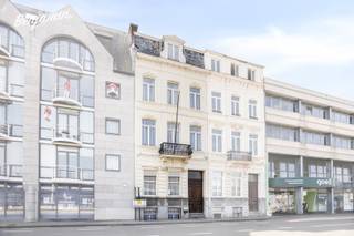 - Herenhuis met grandeur: veel authentieke elementen en hoge plafonds<br />- Topligging in Kortrijk-centrum: Minister Tacklaan 39<br />- Ruime inkomhal met apart toilet<br />- Lichtrijke leefruimte met zithoek en eetplaats<br />- Praktische keuken<br />- Bureau <br />- Toffe, zuidgerichte stadstuin met terras en tuinhuis<br />- 2 slaapkamers op de eerste verdieping, waarvan 1 met wastafel<br />- Badkamer met douchebad en wastafel<br />- 3 slaapkamers op de tweede verdieping, waarvan 2 met wastafel<br />- Ruime, open zolder met mogelijkheid tot 2 extra slaapkamers<br />- Woning is volledig onderkelderd (volwaardige, droge kelder)<br />- Ondergrondse garage in het gebouw ernaast inbegrepen<br />- EPC: 237 kWh/m²/jaar, label C (geen renovatieplicht) UC: 3535811<br />- Overal centrale verwarming<br />- Asbestveilig<br />- Regenwaterput <br />- Richtprijs: € 469.000