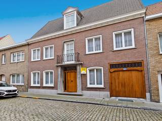 Ruime woning met tal van mogelijkheden centrum Veurne. Gelegen in het centrum van Veurne, op wandelafstand van de Grote Markt, winkels, horeca, scholen en openbaar vervoer, bevindt zich deze uitzonderlijk ruime woning met een bewoonbare oppervlakte van maar liefst 342 m² (volgens epc). Dankzij de doordachte indeling biedt deze eigendom een unieke combinatie van comfortabel wonen en de mogelijkheid om een vrij beroep, praktijk of kantoor aan huis uit te oefenen.<br /><br />Via de statige inkomhal met marmeren vloer en stijlvolle open trap komt u terecht in de verschillende leef- en werkruimtes. Vooraan bevinden zich een ruim bureau/slaapkamer, een onthaalruimte en een wachtkamer, ideaal voor zelfstandigen of wie een professionele activiteit aan huis wenst uit te bouwen. Achteraan geniet u van een lichtrijke leefruimte met een gezellige open haard. De functionele keuken is volledig uitgerust en sluit aan op een praktische bijkeuken met wasvoorzieningen. Verder beschikt het gelijkvloers over een gastentoilet en een inpandige garage.<br /><br />Op de eerste verdieping bevinden zich drie volwaardige slaapkamers. De ruime master bedroom biedt rechtstreeks toegang tot de badkamer. Daarnaast is er nog een praktische berging die perfect dienst kan doen als archiefruimte of extra opbergruimte. De volledig geïsoleerde zolderverdieping biedt tal van mogelijkheden en kan, mits verdere afwerking, ingericht worden als extra slaapkamers, hobbyruimte of polyvalente ruimte.<br /><br />Ook aan bergruimte is er geen gebrek dankzij de volledige onderkeldering met bergkelders en een aparte wijnkelder.<br /><br />Bent u op zoek naar een ruime gezinswoning met een centrale ligging én tal van mogelijkheden voor een zelfstandige activiteit? Dan is deze eigendom in het centrum van Veurne beslist een bezoek waard. Contacteer ons vandaag nog voor meer informatie of een bezichtiging.<br /><br />De vermelde prijs is een richtprijs; elk bod wordt voorgelegd aan de eigenaar, die het recht heeft dit te aanvaarden of te weigeren.<br /><br />Neem voorsprong met een vrijblijvende schatting via:<br />www.residentievastgoed.be/gratisonlineschatten<br /><br />Foto 4,11&amp;13 zijn foto's die bewerkt werden om een voorbeeld te geven hoe de woning kan worden ingericht.