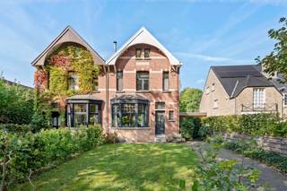 Een gevel die nieuwsgierig maakt, een kleurrijke inkomhal en achteraan een tuin waar het groen alle ruimte krijgt. In de Maria-Theresialei in Mariaburg vind je een woning met een heel eigen karakter. Authentieke details, verrassend veel leefruimte en een indeling die zich makkelijk aanpast aan jouw manier van wonen.<br /><br />De originele tegelvloer en lichtgroene trap geven je bij het binnenkomen meteen een voorsmaakje van wat deze woning zo bijzonder maakt. Hier werden de authentieke elementen behouden en gecombineerd met het comfort van vandaag.<br /><br />Op het gelijkvloers vloeien de verschillende leefruimtes in elkaar over, zonder hun eigen karakter te verliezen. Vooraan is er een gezellige zithoek met authentieke schouw en houtkachel. Centraal is er ruimte voor een bureau, leeshoek of speelplek. Achteraan komt het daglicht volop binnen in de eetkamer, waar je uitkijkt op de tuin. De open keuken met kookeiland sluit hier rechtstreeks op aan en is uitgerust met alle nodige toestellen. Een aparte berging met plaats voor wasmachine en droogkast maakt het geheel extra praktisch.<br /><br />Op de eerste verdieping vind je drie slaapkamers en een badkamer. De afgewerkte zolderkamer biedt nog extra mogelijkheden. Een vierde slaapkamer, een rustige thuiswerkplek of een ruimte voor je hobby's? Je kiest zelf hoe je ze invult. Ook de kelder zorgt voor bijkomende opbergruimte.<br /><br />Buiten is het minstens zo aangenaam. De tuin is groen en beschut, met volwassen bomen en verschillende plekjes om van de rust te genieten. Op het terras is er ruimte om uitgebreid buiten te eten, terwijl je verderop in de tuin altijd wel een rustig hoekje vindt. Je wagen parkeer je op de eigen oprit en voor fietsen is er een aparte berging.<br /><br />Ook de omgeving heeft heel wat te bieden. Mariaburg staat bekend om haar groene straten, karaktervolle woningen en aangename woonomgeving. Winkels, scholen, openbaar vervoer en andere dagelijkse voorzieningen vind je allemaal in de buurt.<br /><br />Een huis dat niet probeert op elk ander huis te lijken. Met authentieke details die het karakter bepalen, ruimte om je eigen plekjes te creëren en een tuin waar je graag tijd doorbrengt.<br /><br />Benieuwd? Kom gerust eens kijken.<br /><br />*Bewoonbare oppervlakte volgens EPC-attest.*