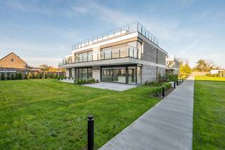 Nieuwbouwappartementen in een moderne stijl worden volledig sleutel op de deur afgewerkt. De appartementen kennen volgende indeling: inkomhal + vestiaire met gastentoilet, berging, keuken, leefruimte met zithoek,  en groot schuifraam naar het terras toe van 12,9m² met tuin. Verder is er 1 slaapkamer, een badkamer met dubbele lavabo, ligbad of inloopdouche. Extra's: epeil 30, centrale verwarming  met individuele warmtepomp en privatieve zonnepanelen. Reeds 70% verkocht!