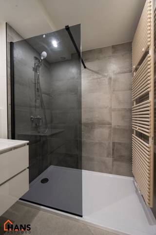 Inkomhal; apart toilet; leefruimte met open keuken met kasten, kookplaat, dampkap en ruimte voor een eigen koelkast en vaatwasser; badkamer...