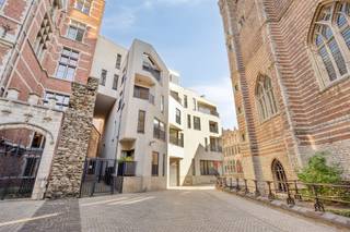 <p>Welkom in dit instapklare 2-slaapkamerappartement op de eerste verdieping van een verzorgd gebouw, gelegen in het historische hart van Antwerpen, vlakbij het Vleeshuis en de Scheldekaaien. Bij het binnenkomen leidt de inkomhal met praktische ingemaakte kasten naar de ruime woonkamer. De woonkamer vormt het hart van het appartement en biedt voldoende ruimte voor een gezellige zithoek en eetplaats. Via de schuifraam kom je rechtstreeks uit op het terras, waar je geniet van het comfort om gezellig iets te eten en te drinken. Aansluitend bevindt zich de open keuken, die in 2022 volledig werd vernieuwd en uitgerust is met kwalitatieve toestellen.<br />Het appartement beschikt over twee slaapkamers, waarvan de hoofdslaapkamer toegang geeft tot het tweede terras, dat uitkijkt op de rustige binnenplaats van de residentie. De badkamer werd eveneens vernieuwd in 2022 en is voorzien van een ruime inloopdouche en dubbele wastafel.<br />Verder zijn er een apart toilet met handenwasser en een ruime berging met aansluiting voor wasmachine en droogkast en voldoende plaats om verschillende zaken in op te bergen.<br />Bij het appartement hoort een <strong>ondergrondse autostaanplaats</strong>, aangeboden aan <strong>€40.000</strong>. Er is tevens een gemeenschappelijke fietsenstalling aanwezig.<br /><strong>LOCATIE</strong><br />Gelegen in een rustige straat midden in het historische centrum, op wandelafstand van de Scheldekaaien, de Grote Markt, het Steenplein en de Onze-Lieve-Vrouwekathedraal. Ook ’t Eilandje en ’t Zuid zijn vlot te voet bereikbaar.<br /><strong>TROEVEN</strong><br />+ Energiezuinig = EPC-label B<br />+ Elektriciteit conform AREI<br />+ Vernieuwde keuken & badkamer<br />+ Praktische ingemaakte kasten in de inkomhal<br />+ Twee terrassen<br />+ Lift aanwezig<br />+ Ondergrondse autostaanplaats aanwezig</p><p><strong>Interesse? Neem contact met ons op en ontdek zelf de troeven van dit appartement tijdens een bezoek ter plaatse.</strong></p>