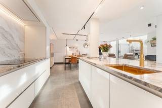 niek appartment centrum waregem, extreem hoge afwerkingsgraad enkel de keuken heeft hier al een waarde van 60.000 euro. <br /><br />Bent u op zoek naar een gelijkvloers appartment met het confort van uw huidige woning? Dan is dit appartment zeker het bezoeken waard. Een stadstuin of zeer ruim terras die zonovergoten is en geniet van volledige privacy.<br />Ik neem u even mee door het appartement:<br />Via de voordeur bereiken we de inkomhal met apart toilet, aansluitend hebben we de lichtrijke living met hoogwaardige keuken. De keuken is hier zeker een grote troef. Volledig voorzien van lades en afgewerkt met een natuursteen werkblad en spatwand.<br />Aansluitend hebben we een grote wasberging en de achterdeur richting de carport, hier kan ook heel vlot een laadpaal voorzien worden.<br />De living geniet van natuurlijk lichtinval en heeft zicht op het zuidgericht terras.<br />Daarnaast zijn er ook nog 2 slaapkamers en een badkamer.<br /><br />Troeven<br />• Instapklaar<br />• hoge afwerkingsgraad<br />• praktische ruimtes<br />• verlichting blijft<br />• carport achteraan<br />• regenput 10.000 l voor prive gebruik<br />• Buitengevel wordt nog volledig geschilderd.<br />Ben jij op zoek naar een appartement met het comfort van een gelijkvloerse woning? Neem dan vandaag nog contact op met ons kantoor.<br />