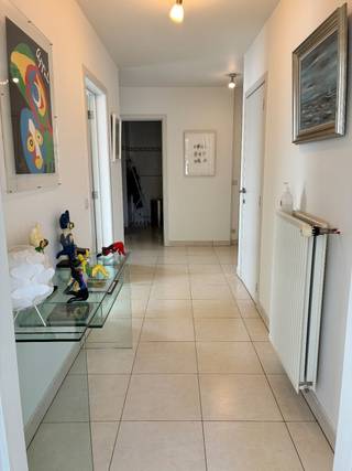 Dit ruime appartement verwelkomt u met een inkomhal en een apart gastentoilet. De lichte en open leefruimte sluit naadloos aan op een volledig uitgeruste keuken en een praktische berging. Via de leefruimte heeft u toegang tot het zonnig terras.<br /><br />Het appartement beschikt verder over twee volwaardige slaapkamers en een comfortabele badkamer met een bad. <br />U kan genieten van de prachtig onderhouden tuin.<br /><br />Extra’s inbegrepen: een ondergrondse autostaanplaats en een privatieve kelderberging.<br />Geen vaste kosten.