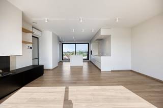 This exclusive building is a true haven of peace, strategically located near the vibrant heart of Aalter. You will be welcomed into an elegant entrance hall with a seamlessly integrated cloakroom. From here, you enter the lush, open living space. This room exudes pure class thanks to the atmospheric gas fireplace and floor-to-ceiling windows that open the space beautifully to the spacious terrace. The hyper-installed custom kitchen is a masterpiece in itself and an absolute dream for every culinary gourmet.The sophisticated night hall leads to a stylish guest toilet and two majestic bedrooms, one of which is fully equipped with floor-to-ceiling wardrobes. Both luxurious bedrooms have their own en-suite bathroom with a spacious walk-in shower. A laundry room and an extremely practical storage room complete the well thought-out layout.This home gem is 100% ready to move in: the interior is fully painted and meticulously provided with mood lighting. You can enjoy a flawless living environment all year round thanks to integrated air conditioning, automatic sunscreens, a ventilation system and private solar panels. An underground cellar and a secure, closed garage box are included as standard and maximize your daily comfort.Trade union information on request.Register of measures: no