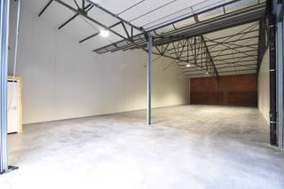 Instapklare, geïsoleerde OPSLAGRUIMTE (200 m²), hoge sectionaalpoort en gemeenschappelijke PARKEERPLAATSEN op ambachtelijke zone te...