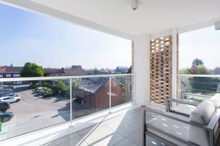 In het rustige Begijnhof van Stabroek bevindt zich dit stijlvol en energie-efficiënt appartement op de tweede verdieping van een kleinschalige residentie. Een lift brengt u rechtstreeks van de kelder of het gelijkvloers tot aan de inkomdeur.<br /><br />De leefruimte geniet van een bijzonder ruimtelijk gevoel dankzij een plafondhoogte van 5 meter en een afwerking met massieve eiken parket. De open keuken is uitgerust met hoogwaardige inbouwtoestellen: een Quooker-kraan, Miele oven en stoomoven, vaatwasser, en een Bora inductiekookplaat met geïntegreerde dampkap. Het werkblad in keramische travertijn is onderhoudsvriendelijk én esthetisch sterk.<br /><br />De badkamer is afgewerkt in dezelfde keramische travertijnlook en voorzien van een uitgekapte inloopdouche en een half vrijstaand ligbad. De afwerking van vloer tot plafond zorgt voor een uniforme, rustige uitstraling.<br /><br />Er zijn twee volwaardige slaapkamers, beide voorzien van elektrische Veluxramen die natuurlijke lichtinval en comfort optimaliseren. Zowel de slaapkamers als de leefruimte beschikken over airconditioning.<br />Extra comfort wordt geboden door zonwerende screens in de leefruimte en badkamer, en op maat gemaakte vliegenramen in heel het appartement. Recent schilderwerk en een volledige afwerking met stijlvolle verlichting maken deze woning volledig instapklaar.<br /><br />Bij het appartement horen twee autostaanplaatsen met laadpunt (à €27.500 per stuk), en een privatieve, afgesloten garagebox met sectionaalpoort (€37.500).<br /><br />Interesse?<br />Contacteer LISTED voor een bezoek: +32 3 283 51 51.<br />