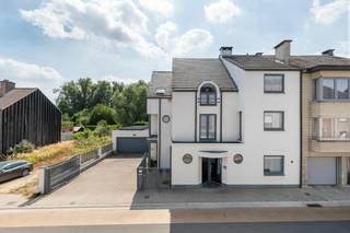Deze verzorgde woning met praktijkruimte biedt maar liefst 471 m² bewoonbare oppervlakte. Door de jaren heen werd het pand consequent onderhouden en vernieuwd, wat resulteert in het stijlvolle en lichtrijke interieur dat de woning vandaag kenmerkt. Achteraan strekt zich een groene, volledig omhaagde tuin uit met zwemvijver en ruim zonneterras, geheel aan het zicht onttrokken, voor maximale rust en privacy. Zowel binnen als buiten valt de uitzonderlijke stilte meteen op.<br /><br />Op het gelijkvloers geeft een aparte ingang toegang tot een gastentoilet, een ruime wachtkamer en een verzorgde praktijkruimte met douchecabine. Verder vindt u hier een groot bureau, meerdere bergingen en een trap naar de opslagkelder. Via een andere deur betreedt u de private inkomhal met de trap naar de eerste verdieping.<br /><br />Op de eerste verdieping bevindt zich de gezellige leefruimte, opgedeeld in een eetkamer, salon en zithoek, en verwarmd door een sfeervolle houthaard. De open geïnstalleerde keuken sluit hier naadloos bij aan. Vanuit de leefruimte hebt u rechtstreeks toegang tot het zonneterras op het verdiep. Een apart toilet en een berging vervolledigen deze verdieping.<br /><br />De tweede verdieping telt drie ruime slaapkamers, een aparte dressing en een luxueuze badkamer met inloopdouche, ligbad en lavabomeubel.<br /><br />De tuin telt tal van gezellige plekjes om tot rust te komen en van het groen te genieten. Enkele jaren geleden werd er een schitterende zwemvijver aangelegd, die het geheel een echte vakantiesfeer geeft. Uw wagens parkeert u in de dubbele garage, uitgerust met laadpaal. Op het dak liggen zonnepanelen.<br /><br />Deze woning combineert wooncomfort, professionele mogelijkheden en een uitzonderlijk aangename buitenruimte.<br /><br /><br /><br />Bestuursmaatregelen in het maatregelenregister: nee