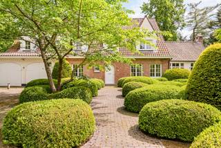 Op een absolute toplocatie in het gegeerde Schilde-Bergen, rustig gelegen nabij St. Ludgardis en omgeven door mature groenaanplantingen, bevindt zich deze perfect onderhouden klassieke villa op een mooi perceel van ca. 2.162 m². De woning biedt royale leefruimtes, 6 slaapkamers, 4 badkamers en een sfeervol bijgebouw achteraan in de tuin. Dankzij de zuidgerichte oriëntatie en de hoogwaardige afwerking is dit een unieke eigendom op één van de meest gegeerde lanen van Schilde.<br /><br />Indeling gelijkvloers:<br />De elegante inkomhal met natuurstenen vloer, vestiaire met gastentoilet en witgelakte trappartij geeft toegang tot de verschillende leefruimtes.<br />De opeenvolging van leefruimtes creëert een heerlijk ruimtelijk gevoel: een zitkamer met openhaard, een aparte eetkamer en een 3e royale leefruimte met grote raampartijen rondom, telkens met zicht op de tuin en directe toegang tot de terrassen.<br /><br />De volledig uitgeruste keuken in tijdloos wit beschikt over een kookeiland, veel kastruimte en kwalitatieve toestellen (o.a. Miele). Aansluitend bevinden zich een praktische voorraadruimte, een ruime wasplaats met ingemaakte kasten, een extra gastentoilet en toegang tot de inpandige dubbele garage.<br /><br />Eerste verdieping:<br />De royale nachthal leidt naar de master suite, bestaande uit een ruime slaapkamer met prachtig tuinzicht over het grote balkon, een volledig ingerichte badkamer met ligbad, inloopdouche, lavabomeubel en toilet, en een uitzonderlijke volledig ingerichte dressing over de volledige lengte.<br /><br />Daarnaast zijn er 3 extra slaapkamers, elk voorzien van ingemaakte kasten, en een bijkomende badkamer met inloopdouche, lavabomeubel en toilet.<br /><br />Tweede verdieping:<br />De tweede verdieping biedt bijkomend woonvolume, met een kleine hal voorzien van linnenkast, 2 ruime slaapkamers waarvan 1 met ingemaakte kasten. Verder is er nog een technische ruimte en een eigen badkamer met inloopdouche, lavabomeubel en toilet.<br /><br />Bijgebouw:<br />Achteraan in de tuin bevindt zich een charmant bijgebouw, volledig opgetrokken in dezelfde klassieke stijl als de woning.<br />Het omvat een inpandige ruimte aan de voorzijde met de installatie voor tuinbesproeiing, een overdekt gedeelte dat geschikt is als zithoekje of voor fietsen, en een achtergedeelte dat gebruikt werd als hondenhok/berging.<br />Via een vaste trap bereikt men de bovengelegen ruimte, ideaal als atelier, speelruimte, kantoor of gastenverblijf.<br /><br />Dit bijgebouw vormt een sterke functionele meerwaarde voor het perceel.<br /><br />Bijzonderheden:<br />- Zuidgerichte, volledig aangelegde en omheinde tuin<br />- Tijdloze architectuur en hoogwaardige afwerking<br />- 6 slaapkamers – 4 badkamers – ruime dressing<br />- Inpandige dubbele garage<br />- Automatische poort<br />- Bijgebouw met diverse gebruiksmogelijkheden