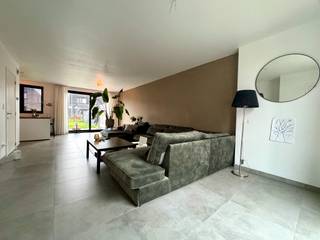 BENIEUWD? VRAAG EEN BEZOEK AAN VIA WWW. HILLEWAERE.BE EN KLIK OP DE RODE KNOP 'BEZOEK INPLANNEN'.<br /><br />Op zoek naar een moderne woning waar je gewoon je meubels moet binnenzetten en klaar? Dan zit je hier goed. Deze recente woning (bouwjaar 2023) ligt in een rustige woonwijk, op wandelafstand van de dorpskern en vlak bij de school. Handig voor wie kinderen heeft.<br /><br />De woning verrast meteen met haar ruimte en lichtinval. Je komt binnen via de inkomhal met gastentoilet, waarna je terechtkomt in de leefruimte. De open keuken is uitgerust met alles wat je nodig hebt: een inductiekookplaat, combi-oven, koelkast en vaatwasser. Koken met zicht op de tuin? Altijd een plus.<br /><br />Via de eetkamer en keuken heb je toegang tot het terras en de tuin, die trouwens zuidwest georiënteerd is. De tuin is groen, maar onderhoudsvriendelijk. Je hebt er dus plezier van, zonder al te veel werk.<br /><br />Aansluitend aan de woonkamer (via een kleine hal) vind je de inpandige garage met automatische poort. Handig detail: je geraakt ook via een achterdeur rechtstreeks in de tuin, ideaal voor vuilbakken of fietsen. In de garage zijn ook aansluitingen voorzien voor wasmachine en droogkast.<br /><br />Op de bovenverdieping zijn er drie ruime slaapkamers en een moderne badkamer met inloopdouche en dubbele wastafel. <br /><br />Wat moet je zeker onthouden?<br />- Nieuwbouw uit 2023: alles is nog zo goed als nieuw<br /> - Energiezuinig én comfortabel: vloerverwarming via warmtepomp (met koelfunctie)<br />- Regenwater wordt hergebruikt<br />- Beschikbaar vanaf 1 juni 2026<br />- Zonnige tuin + terras