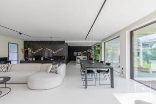 Deze uitzonderlijke <strong>villa met handelspand</strong> (momenteel ingericht als kapsalon) beschikt over een <strong>bruikbare vloeroppervlakte van ca. 352 m²</strong> en is gelegen in <strong>Mariakerke</strong> op een perceel van maar liefst <strong>1.181 m²</strong>. De woning geniet bovendien van een zuidgerichte oriëntatie.<br /><br />Het betreft een <strong>vernieuwbouw uit 2017</strong>, gerealiseerd met oog voor <strong>kwaliteit en duurzaamheid</strong>. De woning is uitgerust met aluminium ramen met dubbele beglazing, ventilatie type D, <strong>domotica</strong>, zonnescreens, <strong>vloerverwarming</strong> op zowel het gelijkvloers als de verdieping, een <strong>zonneboiler</strong> en volledig vernieuwde technieken. In 2020 werden bovendien <strong>43 zonnepanelen</strong> geplaatst. Dit resulteert in een uitstekende EPC-score van 91 kWh/m²/jaar (<strong>label A</strong>). Dit attest dateert van vóór het plaatsen van de zonnepanelen.<br /><br />De <strong>handelsruimte aan de voorzijde</strong> op het gelijkvloers is momenteel ingericht als kapsalon en heeft een oppervlakte van ca. 45 m². Deze ruimte kan perfect worden ingericht als ruimte voor een vrij beroep of praktijk, maar kan evengoed worden omgebouwd tot een inpandige dubbele garage. De nodige structuur en openingen hiervoor zijn reeds voorzien.<br /><br />Via de afzonderlijke inkomhal met gastentoilet is er toegang tot de zeer ruime woonkamer met eetplaats, die in verbinding staat met de <strong>volledig geïnstalleerde keuken</strong>. De berging/wasplaats, grenzend aan de keuken, geeft toegang tot de <strong>bijzonder ruime kelder</strong>. De woning is namelijk volledig onderkelderd. In de kelder bevinden zich aan de ene zijde de technische installaties, terwijl de andere zijde momenteel is ingericht als mancave.<br /><br />De aangelegde tuin beschikt over een <strong>overdekt terras</strong> dat volledig kan worden afgesloten, evenals een tuinhuis met carport aan de linkerzijde van het perceel.<br /><br />Op de eerste verdieping bevinden zich de <strong>masterbedroom met dressing</strong>, twee kinderkamers met een afzonderlijke badkamer, een logeerkamer, een bureauruimte (die als 5de slaapkamer kan dienen) en een tweede badkamer met ligbad en douche.<br /><br />Wenst u zelf de vele kwaliteiten en troeven van deze unieke villa te ontdekken? Neem dan contact op met Theo voor een bezoek ter plaatse via theo@convas.be.