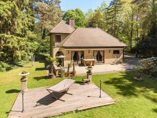 In de groene en gegeerde buurt Steijnhoeven bevindt zich deze villa op een achterliggend perceel van 3.905m². Achter een automatische toegangspoort en via een lange oprijlaan geniet u hier van absolute privacy, ruimte en rust.<br />De woning beschikt over een bew. opp. van ca. 309 m² en combineert volume, functionaliteit en een zeer gunstige EPC-score (label B – 197 kWh/m²).<br /><br />Indeling gelijkvloers:<br />Via de lichtrijke inkomhal betreedt u de royale leefruimte met zitgedeelte en imposante open haard als centrale blikvanger. Aansluitend bevinden zich de eetkamer en een ruime keuken met zicht op de tuin. Verder omvat het gelijkvloers een praktische berging, wasplaats, een polyvalente ruimte/bureau en een volwaardige slaapkamer met en-suite badkamer — ideaal voor gelijkvloers wonen of praktijk aan huis.<br /><br />Eerste verdieping:<br />De open vide creëert een aangenaam ruimtelijk gevoel en behoudt het contact met de leefruimte beneden. Hier bevindt zich een tweede leefruimte met annex slaapkamer. Via een aparte trap, bereikbaar vanuit het bureau, komt u bij een bijkomende slaapkamer met eigen badkamer. In totaal telt de woning 4 slaapkamers, 2 badkamers.<br /><br />Buitenruimte en bijgebouw:<br />Het perceel is volledig omgeven door groen en heeft gezien zijn centrale ligging achteraan het perceel een perfecte zonne-oriëntatie. Op het terras of in de jacuzzi ervaart u maximale rust en discretie.<br />Achteraan het perceel bevindt zich een ruim bijgebouw met tal van invullingsmogelijkheden: dubbele garage, atelier, poolhouse, praktijkruimte of kangoeroewonen.<br /><br />Bijzonderheden:<br />– Aparte dubbele garage (meerdere functies mogelijk)<br />– Zeer goed onderhouden woning<br />– Residentiële ligging<br /><br />Een ideale eigendom voor wie ruim en groen wil wonen in een kwaliteitsvolle woonomgeving, met het comfort van een energiezuinige woning en tal van mogelijkheden voor wonen en werken onder één dak.