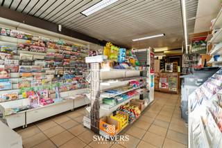 Voor meer info en foto’s, surf naar www.swevers.be – Op de centrale Grote Baan in Houthalen-Helchteren ontdek je deze verrassend ruime woning met handelsruimte. Met een bewoonbare oppervlakte van 188 m² en een perceel van 4a 09ca biedt dit pand talloze mogelijkheden voor wie wonen en werken wil combineren. De gelijkvloerse handelsruimte van 50m² heeft een aparte inkom en is vandaag ingericht als krantenwinkel, maar is ook perfect inzetbaar als kantoor, praktijk of winkel. Het woongedeelte omvat onder meer een lichtrijke leefruimte, keuken, gastentoilet en berging. Boven zijn er vier volwaardige slaapkamers en een badkamer. Dankzij de vaste trap naar de tweede verdieping benut je elke ruimte optimaal. Extra troeven zijn de kelder (17 m²), werkplaats van 99 m² en ruime garage van 45 m² met achteringang, westelijk georiënteerde tuin, airco, alarmsysteem en zonnepanelen. Scholen, winkels, openbaar vervoer en autosnelweg bevinden zich op korte afstand. Een veelzijdige woning met potentieel, klaar voor jouw invulling. Voor meer informatie, bel 011 255 155. Bron bewoonbare oppervlakte: EPC – verslag.