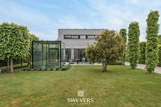 Voor meer info en foto’s, surf naar www.swevers.be – Deze stijlvolle open bebouwing in het gegeerde Bolderberg combineert luxe, comfort en rust op een uitzonderlijke locatie. Gelegen in een doodlopende straat nabij circuit Zolder geniet u hier van maximale privacy, een prachtig aangelegd perceel van 11a 60ca en een instapklaar geheel met hoogwaardige afwerking. De woning werd gebouwd in 2003 en doorheen de jaren zorgvuldig vernieuwd, met onder meer een vernieuwde badkamer, zonnepanelen, een volledig heraangelegde tuin en een nieuwe boiler. Binnen zorgt de lichtrijke leefruimte dankzij de grote raampartijen voor een aangename sfeer en een mooi zicht op de tuin. Het gelijkvloers beschikt verder over een open keuken van 16 m² met aansluitend een aparte berging, een apart gastentoilet en een bureau. Vloerverwarming in combinatie met extra radiatoren garandeert optimaal wooncomfort. Op de verdieping bevinden zich twee zeer ruime slaapkamers van 20 m² en 31 m² met badkamer, apart toilet en extra opbergruimte. De vrijstaande garage van 42 m² biedt bijkomende plaats voor wagens, fietsen of hobbyruimte. Ook buiten is het volop genieten. De tuin werd volledig heraangelegd en beschikt over een automatisch sproeisysteem. Dankzij de zonnepanelen en het alarmsysteem scoort de woning eveneens uitstekend op vlak van energiezuinigheid en veiligheid. De ligging is een extra troef, met winkels, scholen, restaurants en openbaar vervoer vlakbij en een vlotte verbinding naar de autosnelweg. Een ideale woning voor wie op zoek is naar ruimte, kwaliteit en comfortabel wonen in een groene en residentiële omgeving. Voor meer informatie, bel 011 255 155. Bron bewoonbare oppervlakte: EPC – verslag.
